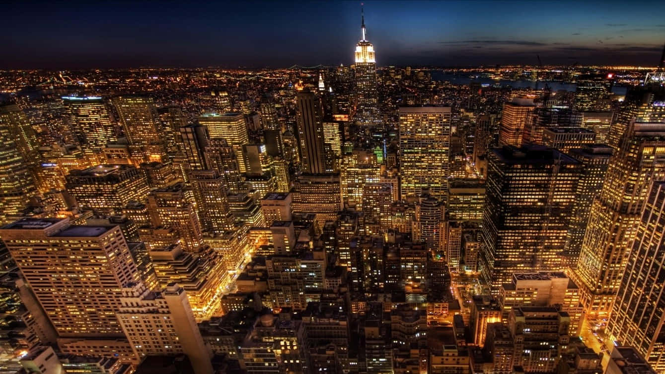 夜晚紐約市天際線的空中景觀，摩天大樓閃閃發光，帝國大廈亮起。