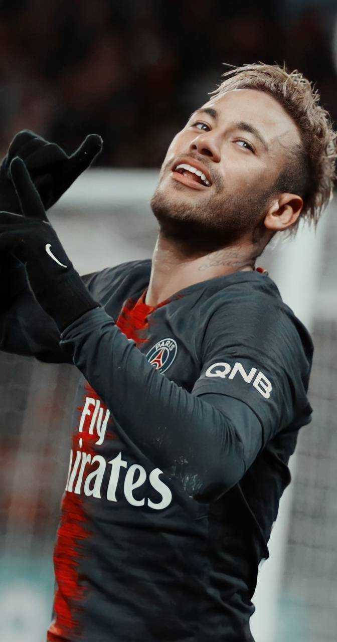 足球運動員在體育場高舉雙手慶祝勝利。