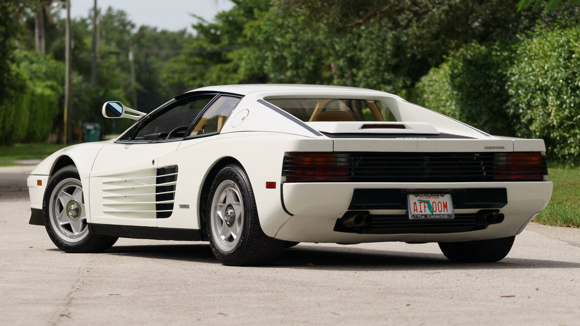白色法拉利 Testarossa 停泊在林蔭大道上。