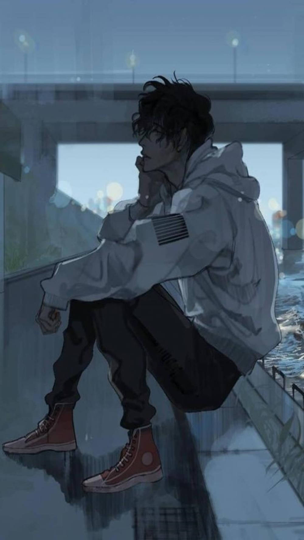 穿著連帽衫的年輕男子在黃昏的雨中獨自坐在濕漉漉的城市邊緣。