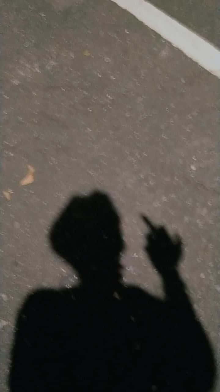 夜晚在路面上用手指指點的人的影子