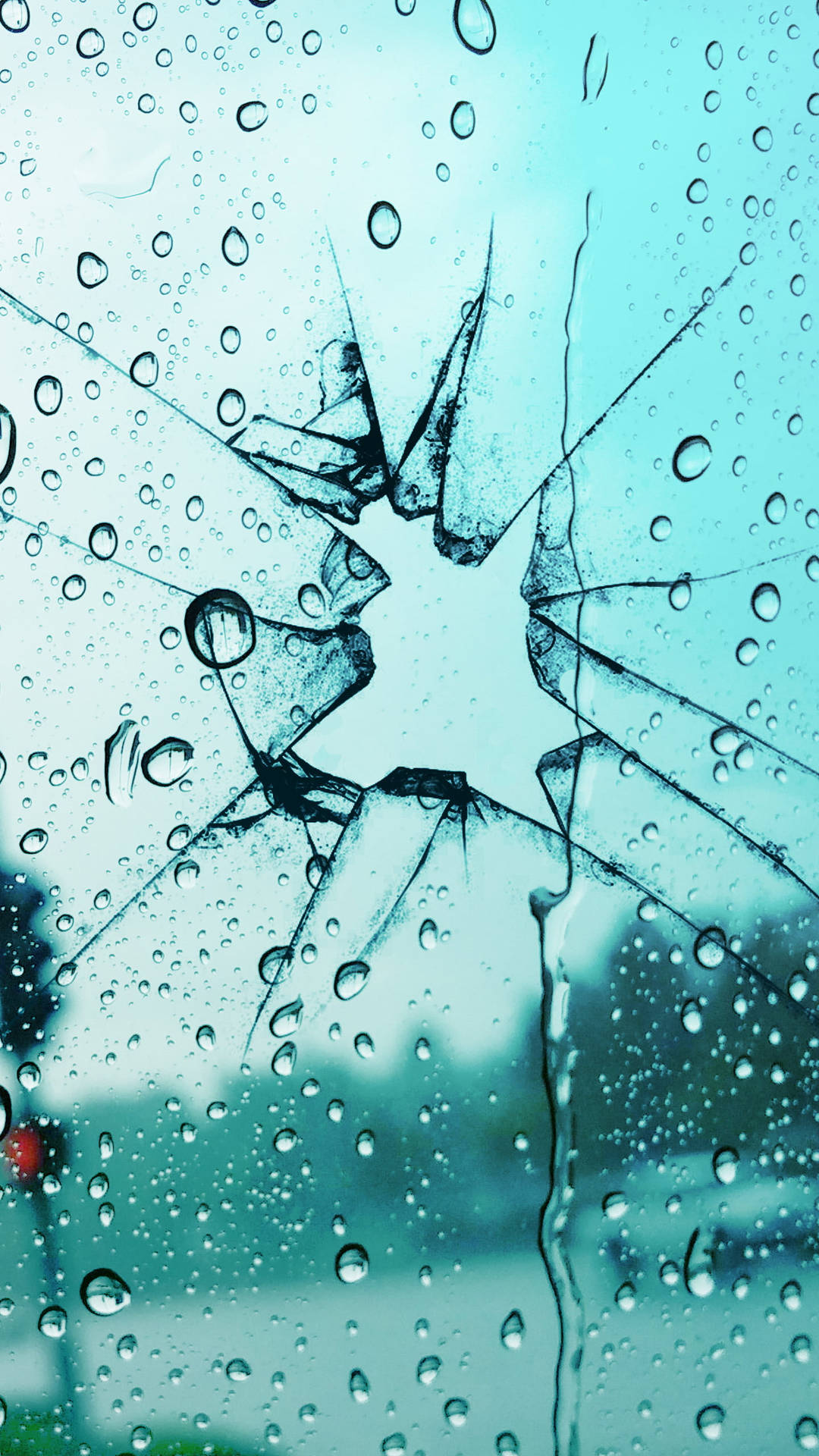 破碎玻璃窗上的雨滴，帶有星形裂紋。