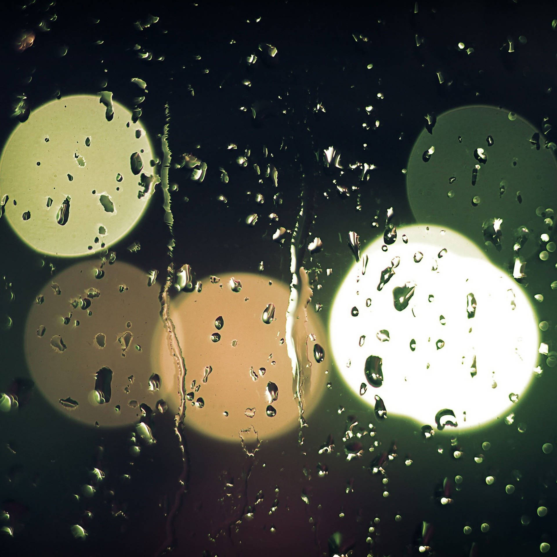 窗戶上的雨滴，夜色中模糊的街燈閃爍。