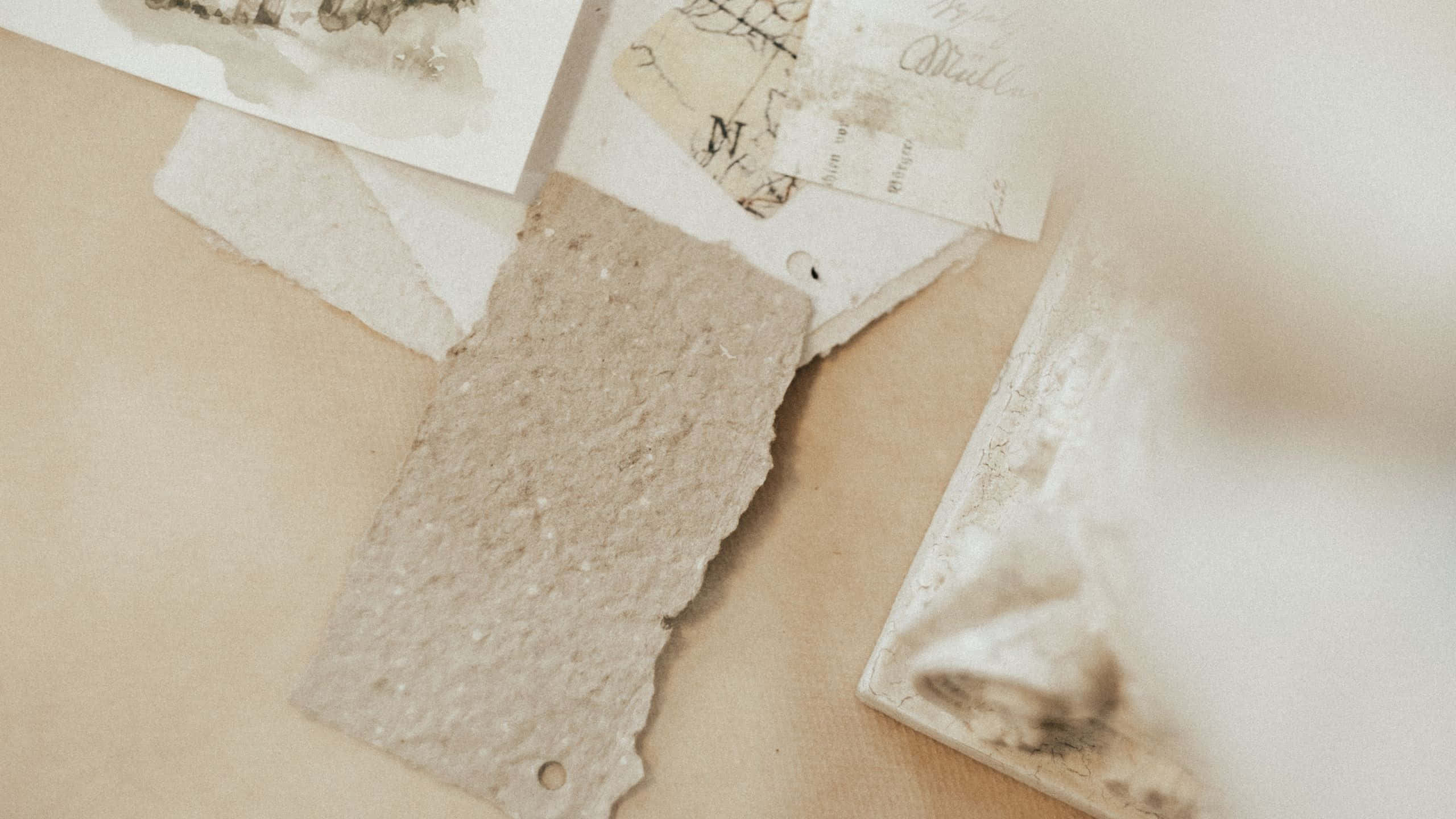 Vintage Aesthetic 桌布 壁紙 — 帶有手寫文字的復古撕紙和帶紋理的米色碎片輕輕地放在暖色調的表面上。
