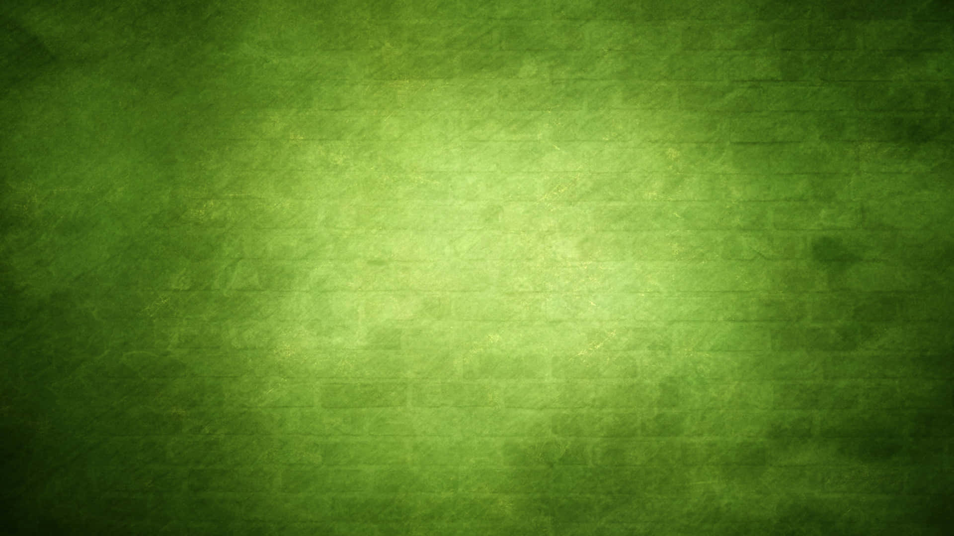 Green Texture 桌布 壁紙 — 帶有紋理的綠色磚牆，帶有從深綠色漸變到淺綠色的柔和光暈。