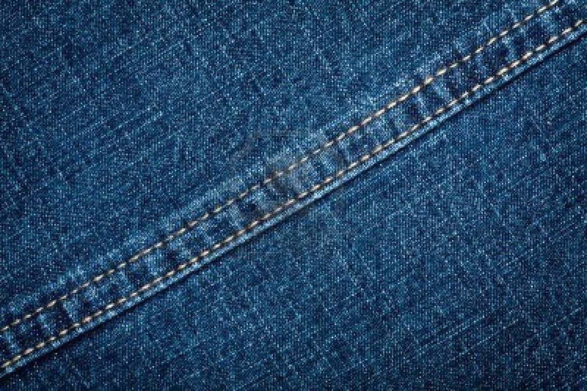 Jeans 桌布 壁紙 — 帶有紋理的藍色牛仔布特寫，金色斜線縫合突顯織物紋理和接縫。