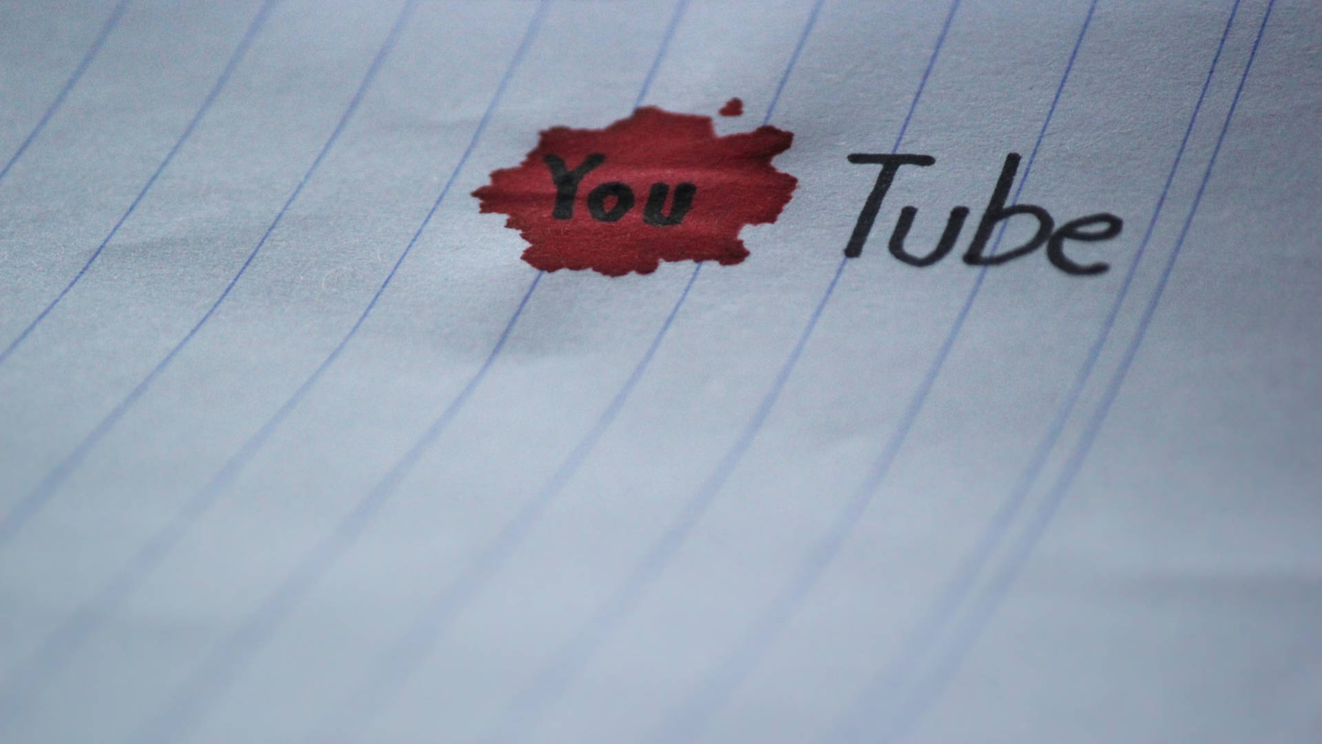 紅色墨跡遮蓋了橫線紙上YouTube標誌中的「You」。