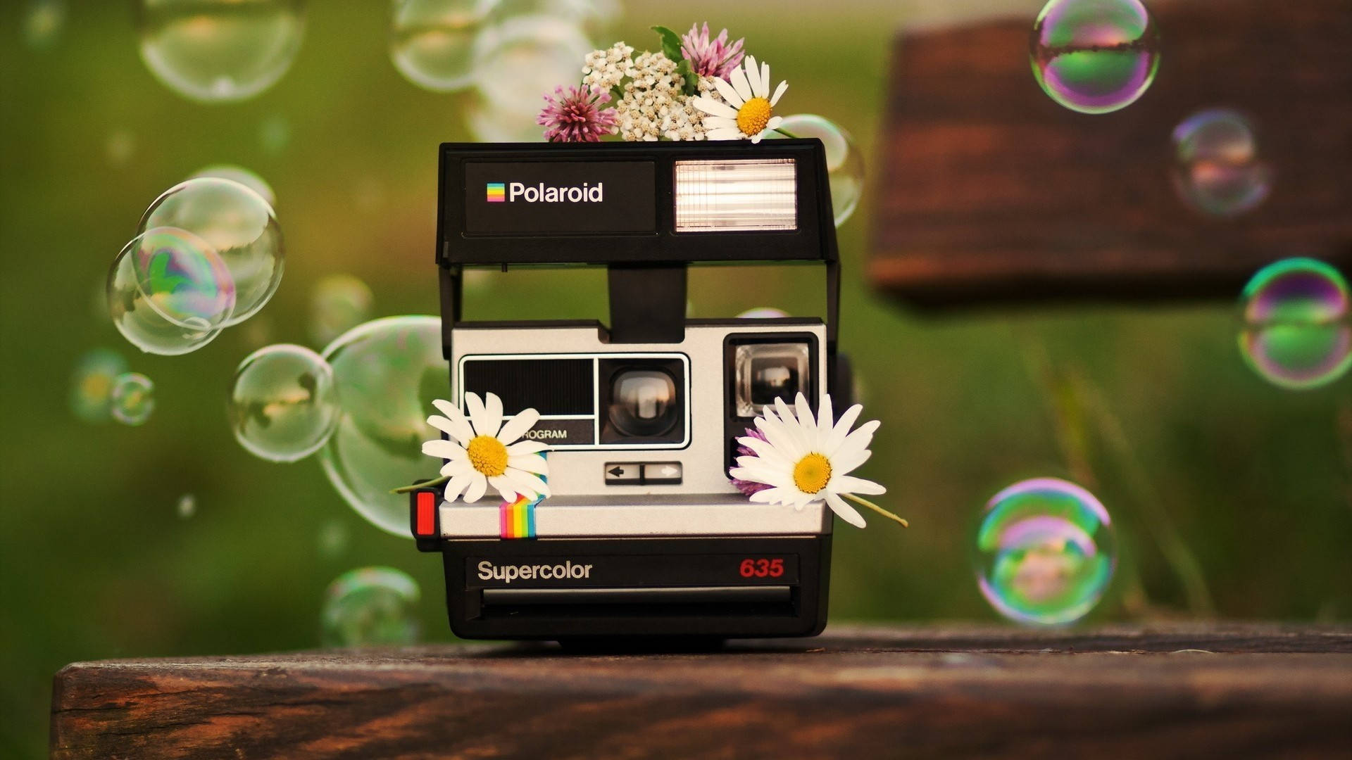 復古Polaroid相機，裝飾有花朵和泡泡，置於木質表面。