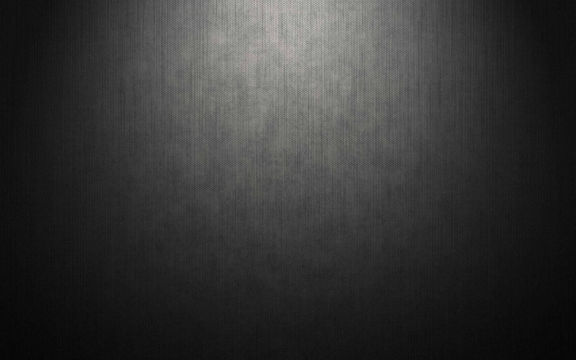 帶有聚光燈漸變效果的黑暗紋理表面。