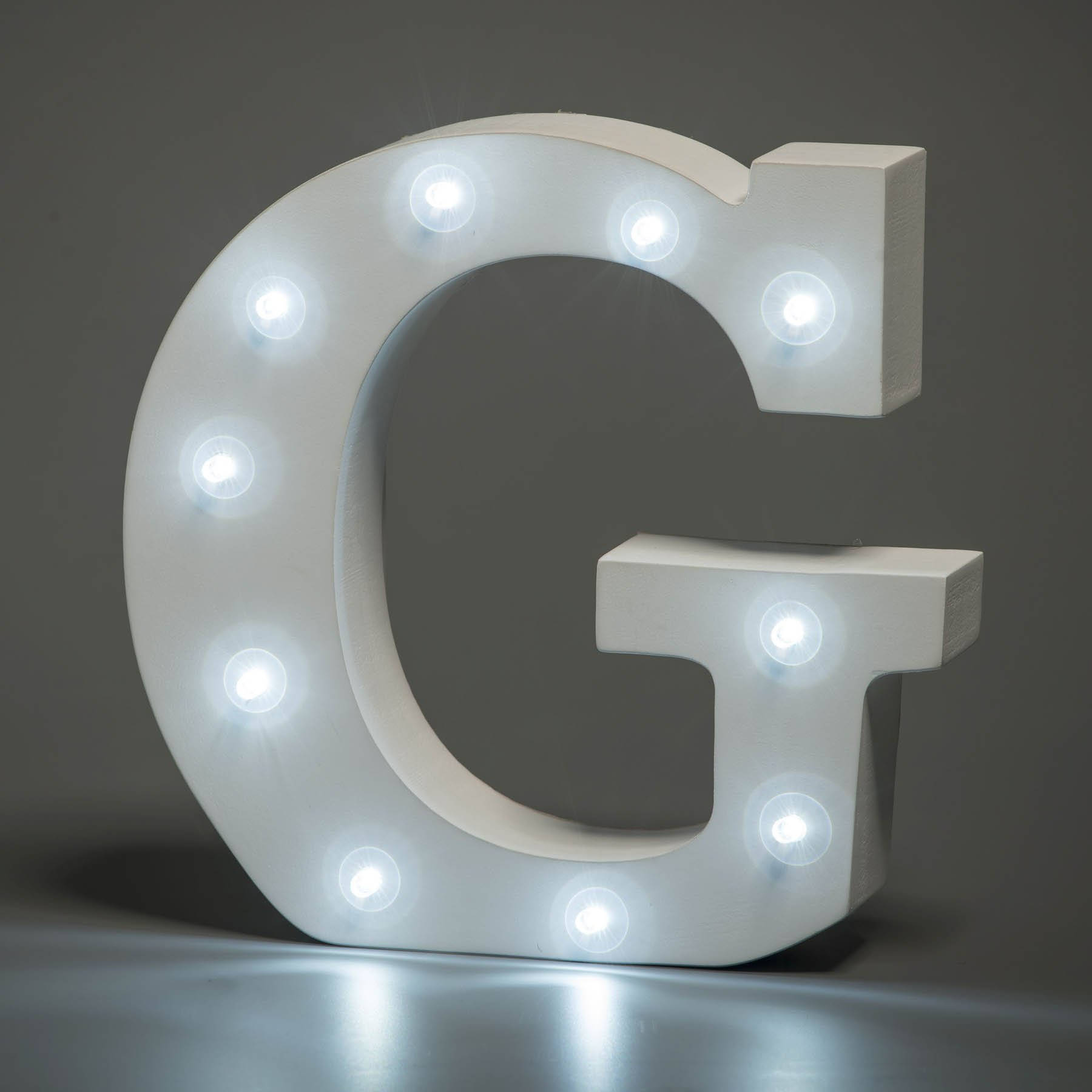 白色發光字母G，帶有發光燈泡，在反射表面上。