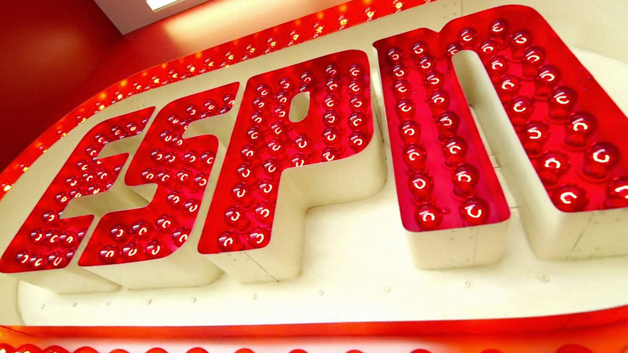 帶燈光的ESPN標誌 壁紙 — 紅色牆壁上帶有白色字體和球狀燈光的發光紅色ESPN標誌特寫。