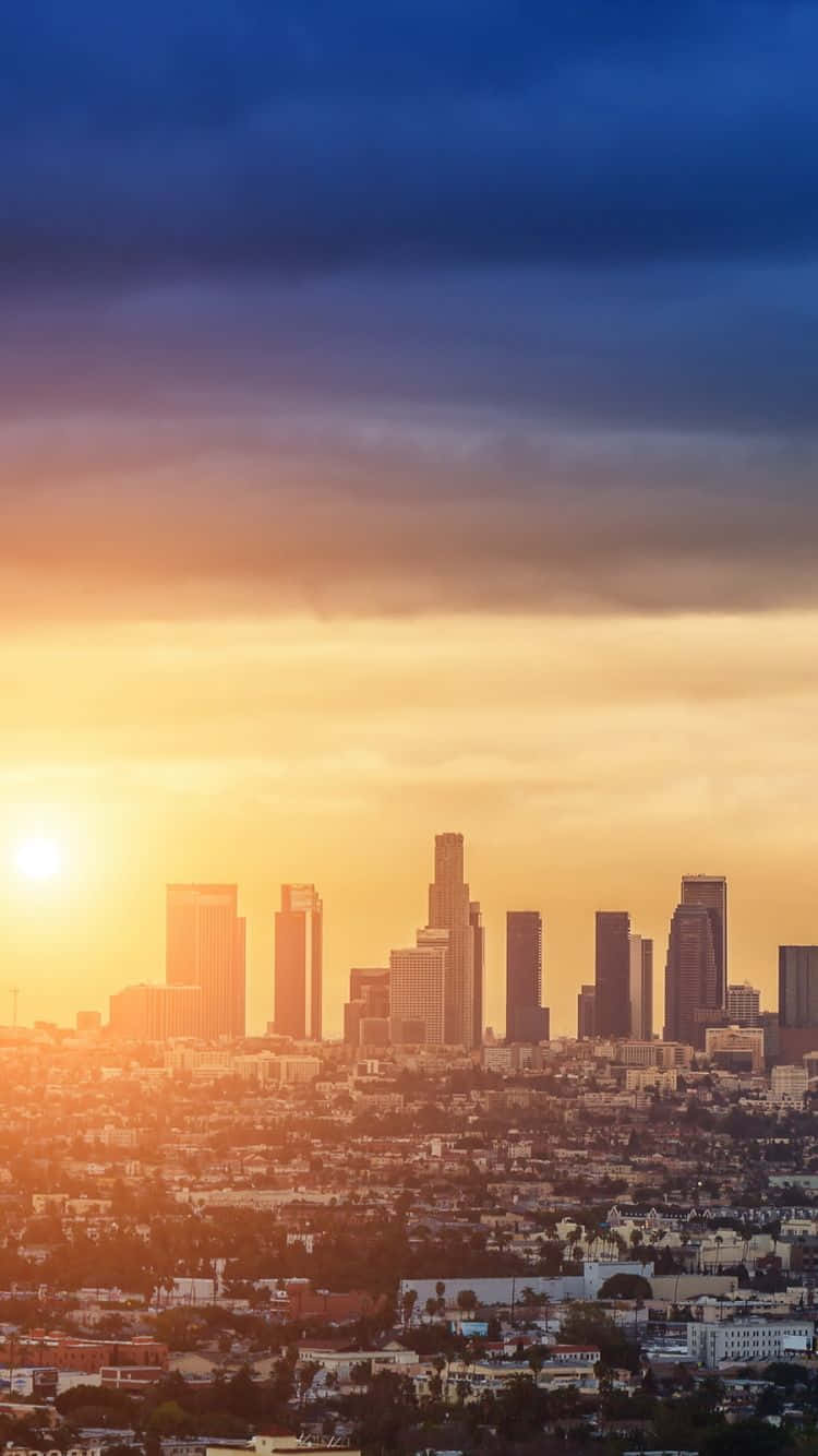 洛杉磯日落天際線，帶有橙色光芒和烏雲。