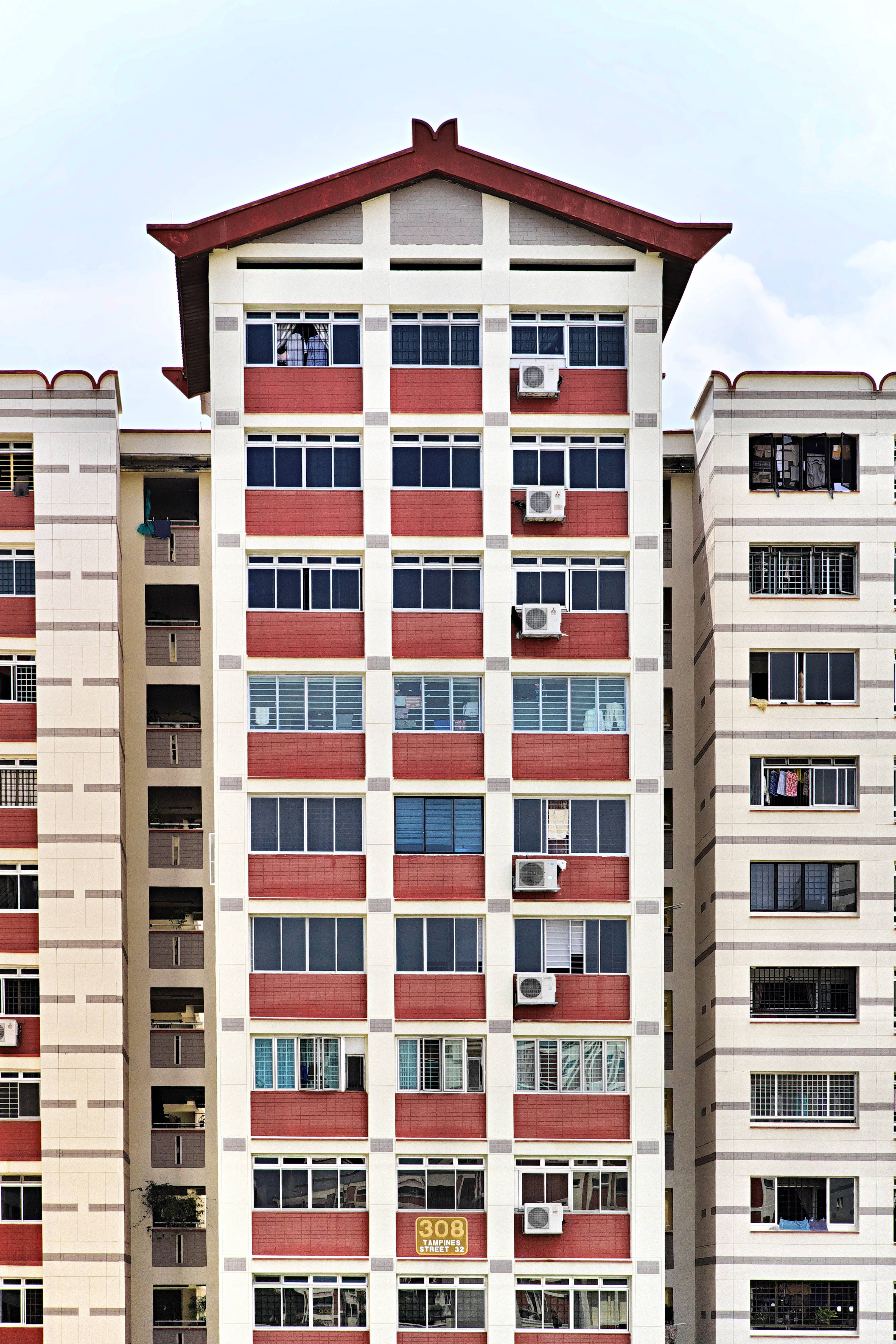 帶鋭頂屋的白色建築 壁紙 — 高層住宅公寓大樓，紅白外牆，眾多窗戶，晴空萬里。