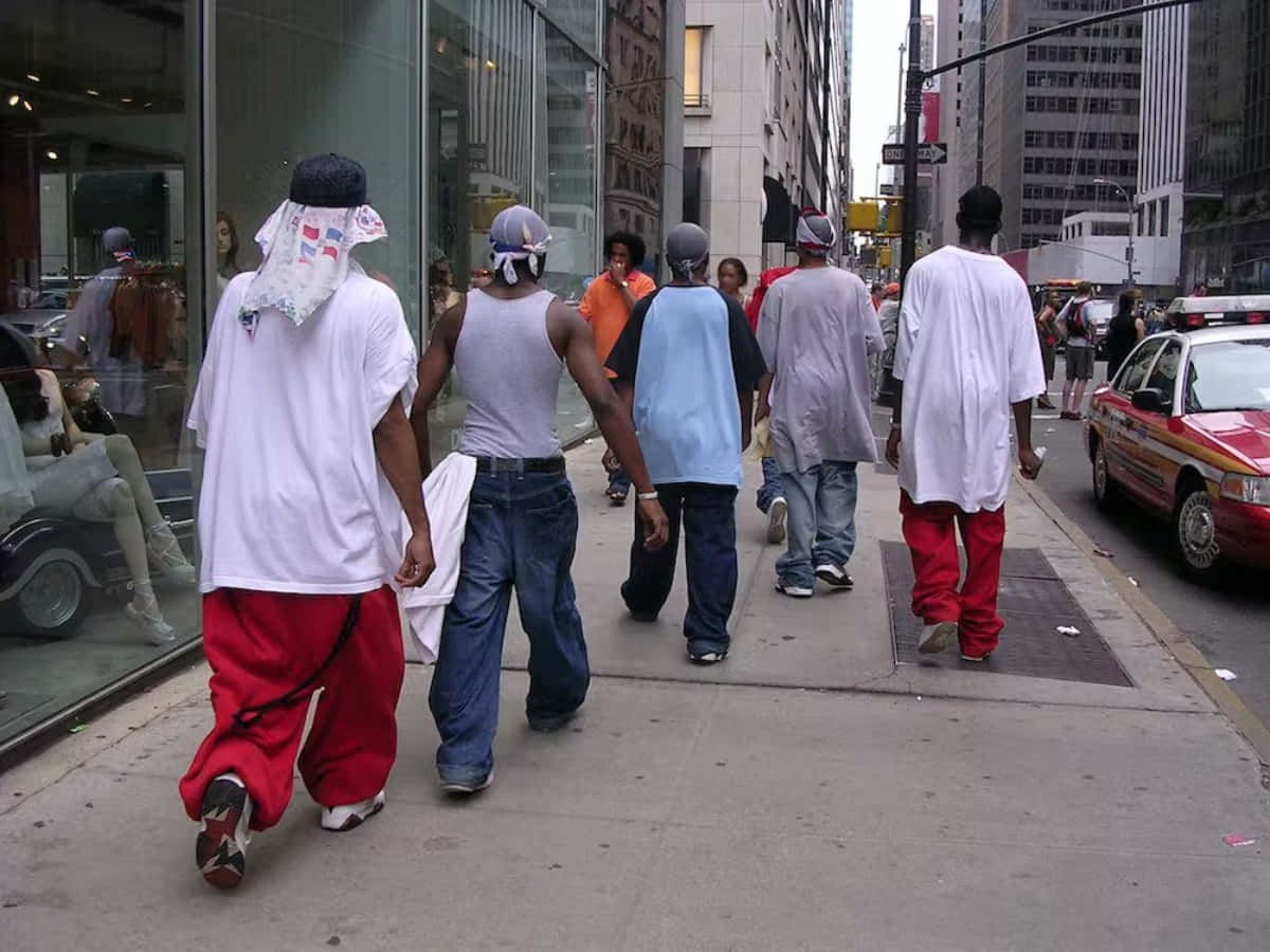 一群男人在商店和出租車附近的城市人行道上走開。
