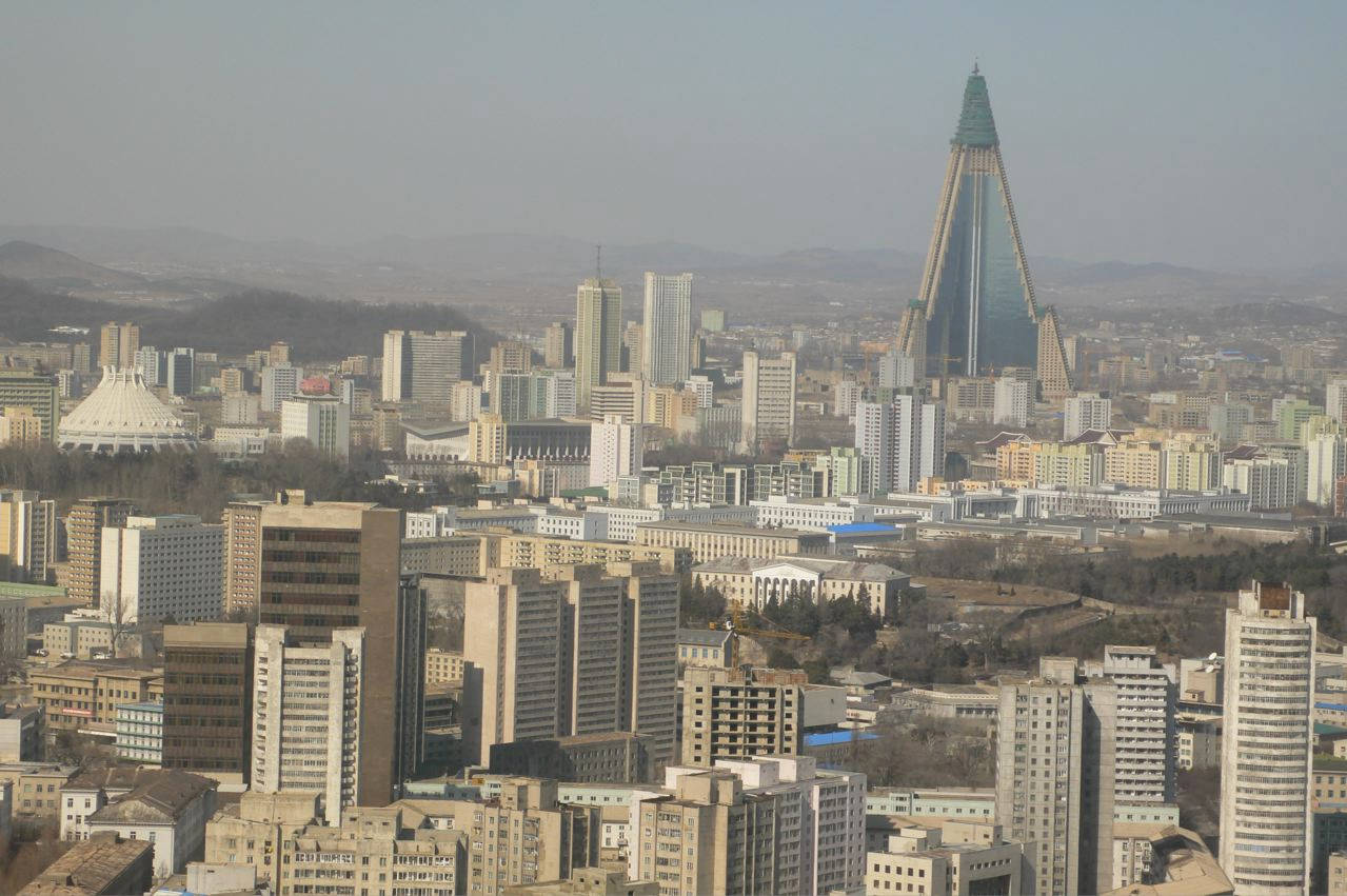 一片朦朧的城市景觀，有一座突出的玻璃金字塔摩天大樓及周圍建築。