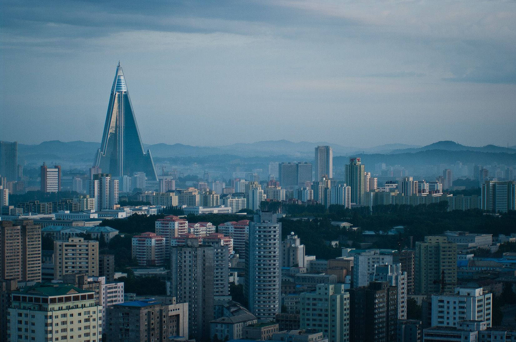 多雲天空下，黃昏時分擁有獨特金字塔摩天大樓的城市景觀。
