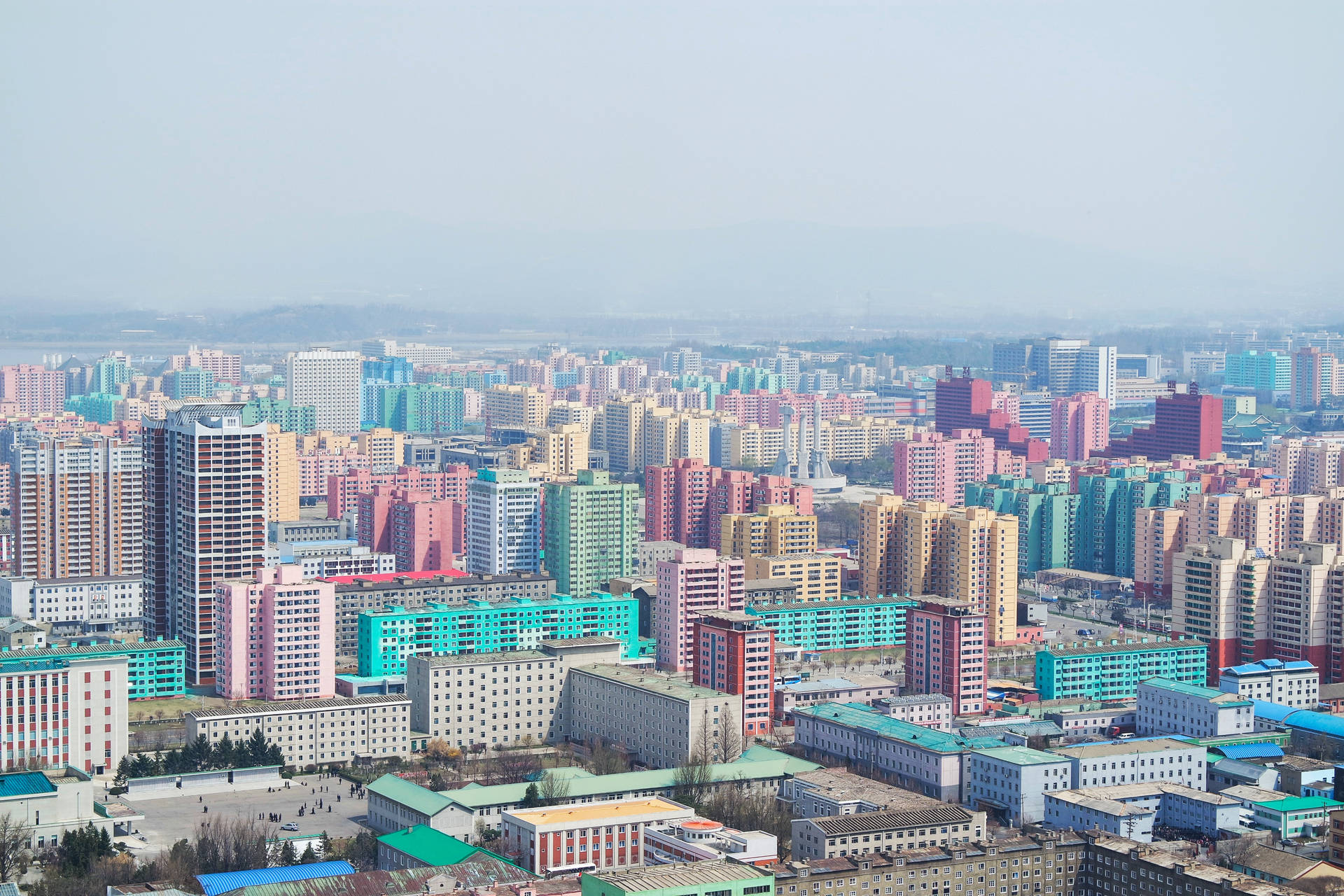 在朦朧的天空下，密集的城市景觀中色彩繽紛的高層建築。