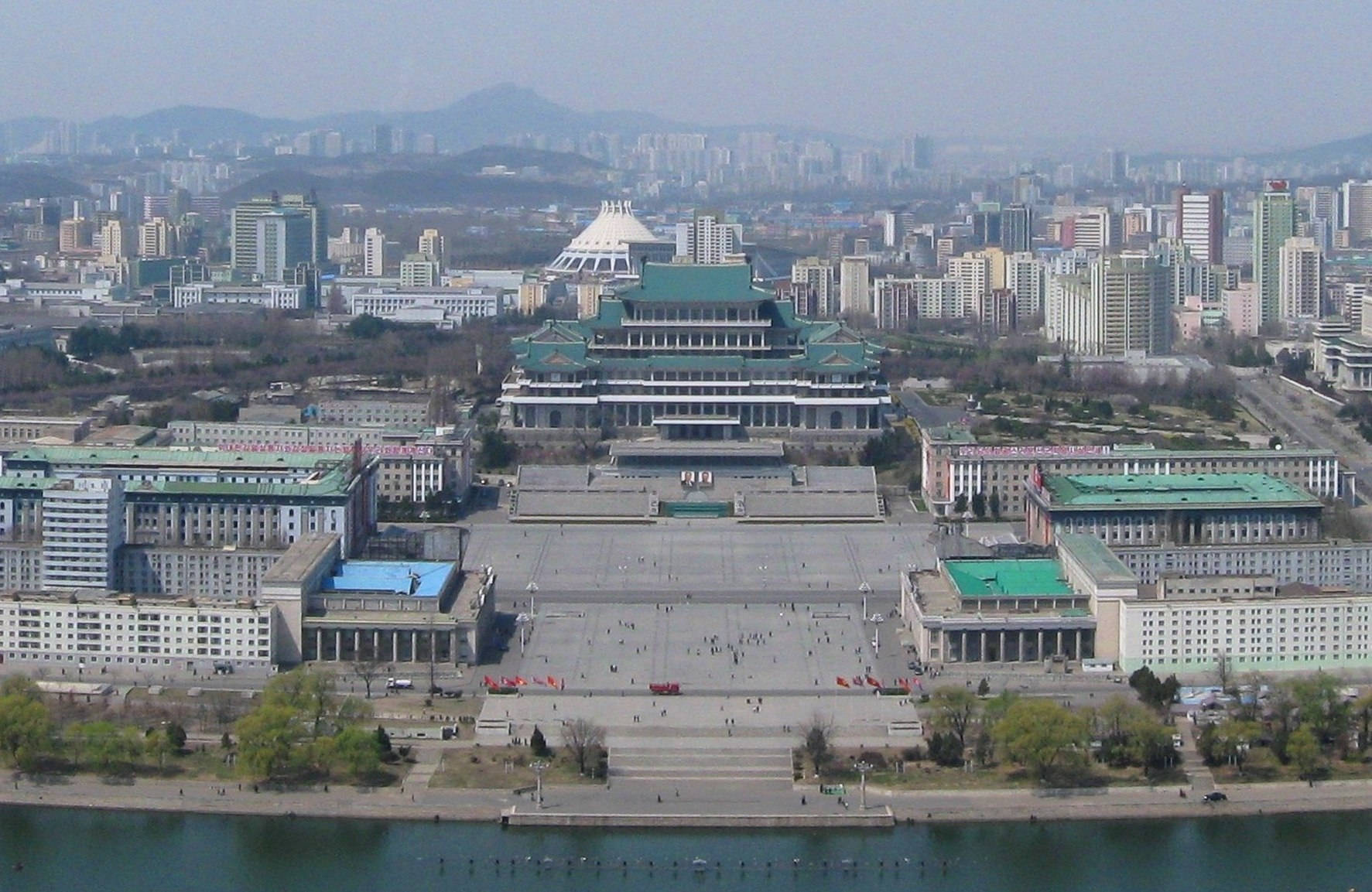 宏偉的綠色屋頂宮殿建築群，被城市建築和一條河流環繞。