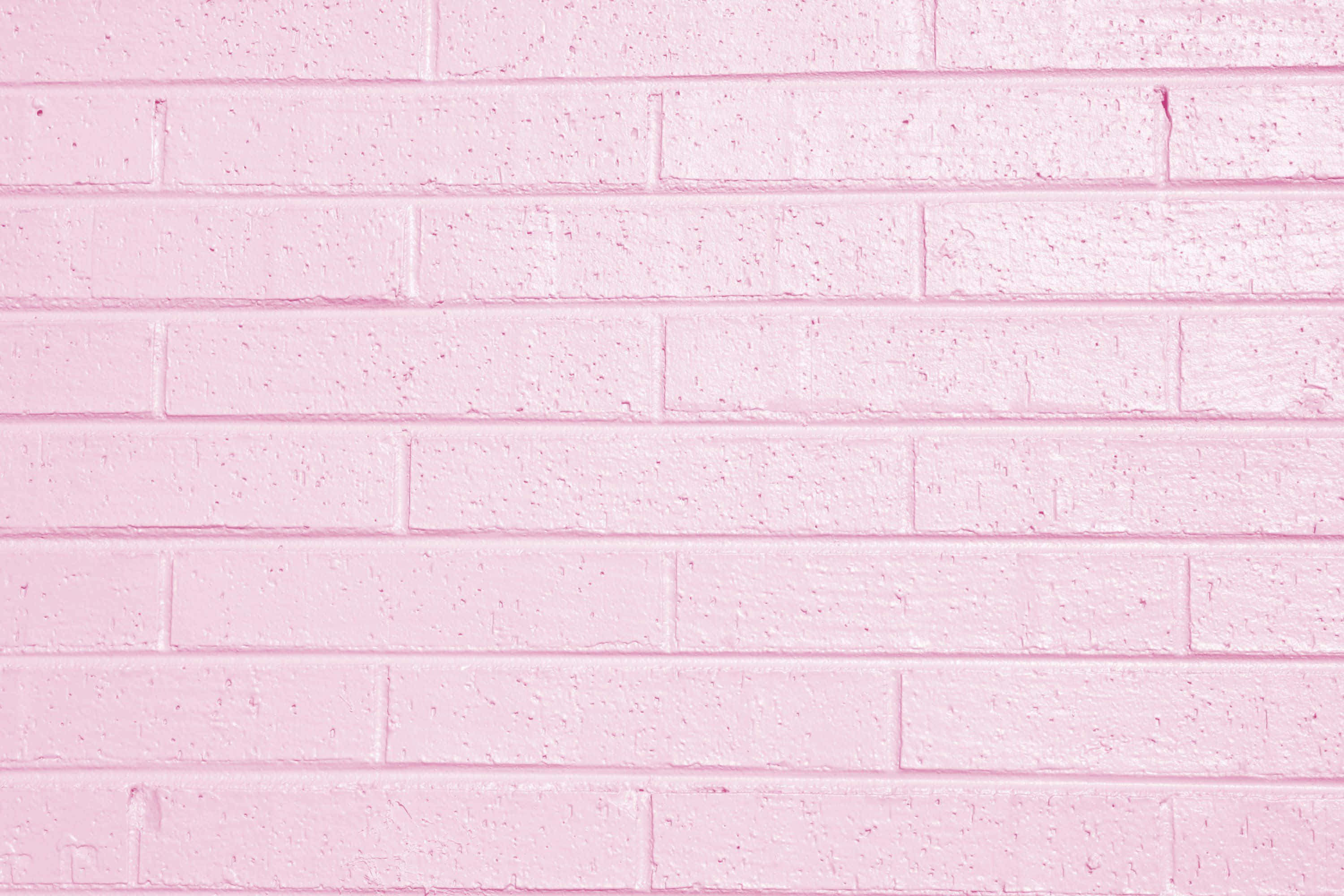 Pink Wall 桌布 壁紙 — 平滑粉紅色磚牆的特寫，可見砂漿線條和細微紋理。