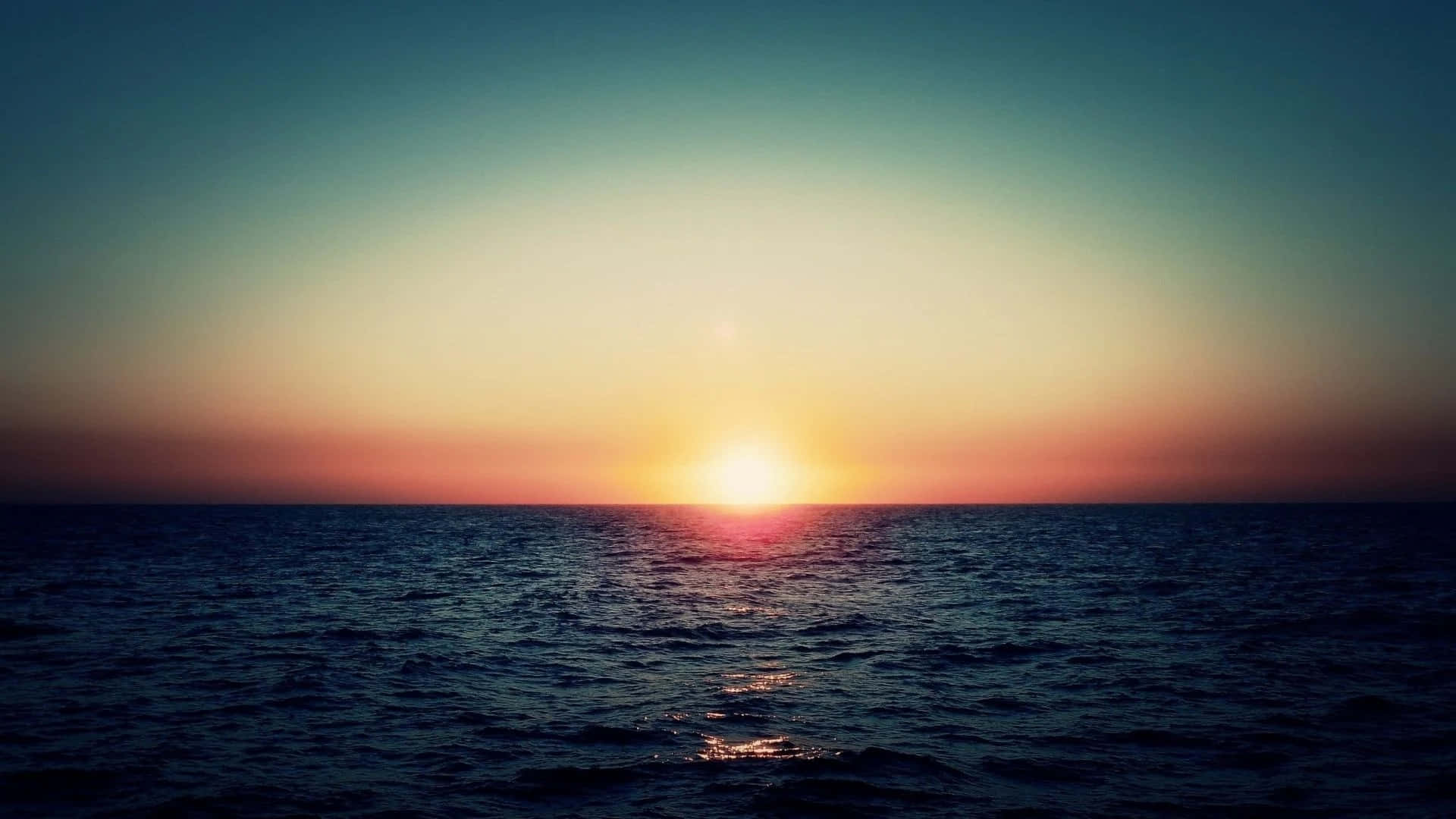 Twitter Header 桌布 壁紙 — 平靜海面上的寧靜日落，金色太陽沉入地平線，溫暖的光芒灑滿天空。
