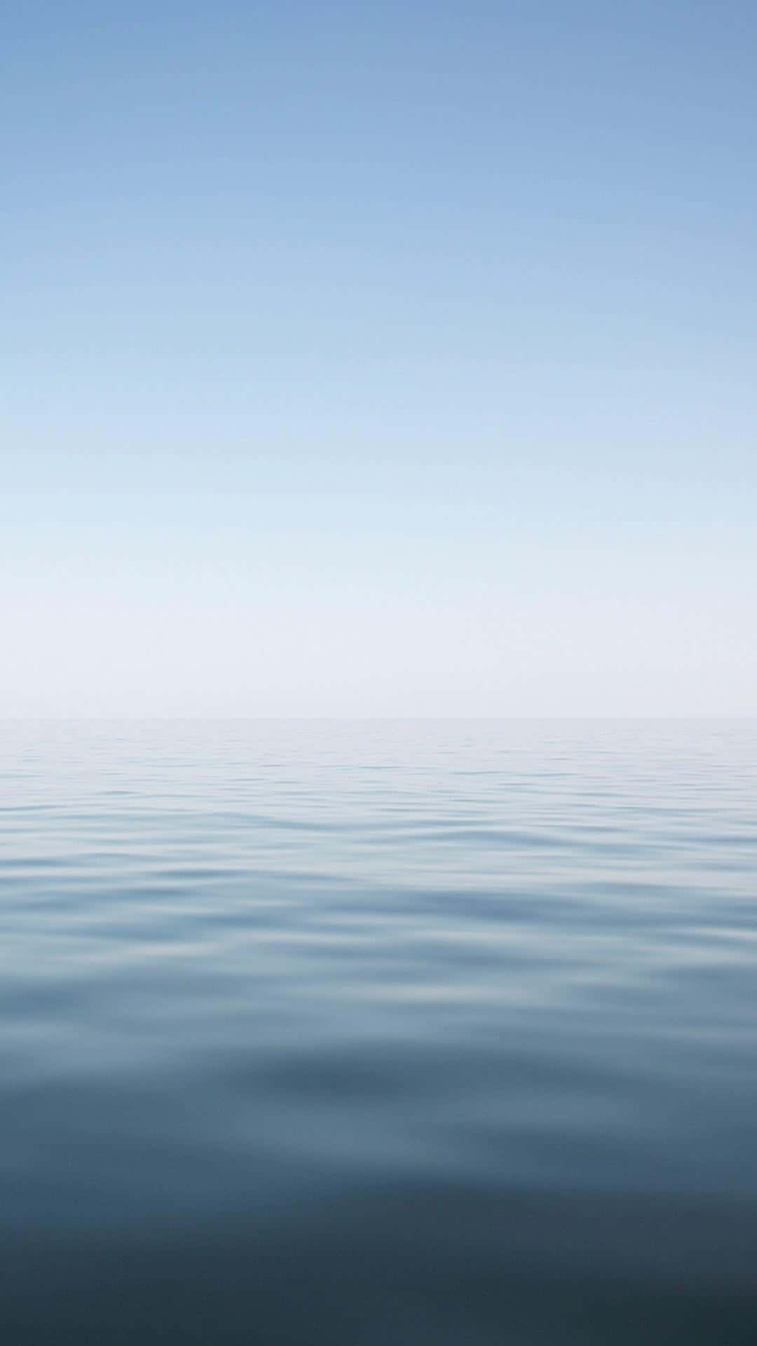 Minimalist Ocean 桌布 壁紙 — 平靜的藍色海水與柔和漸變的天空在寧靜中相遇的安詳地平線。