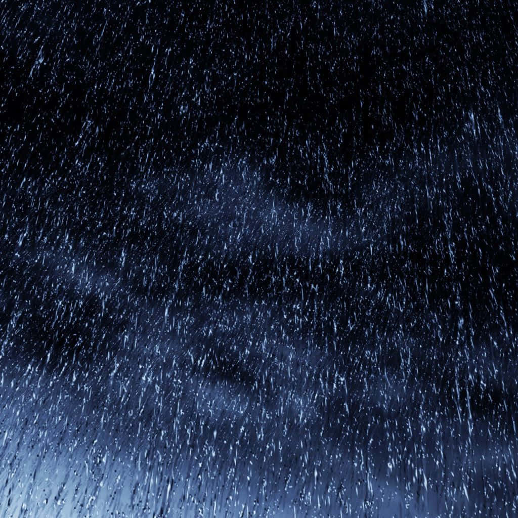 大雨在黑暗的夜空中伴隨藍色燈光落下。