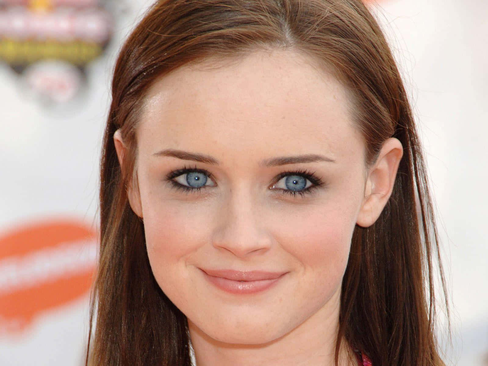 Alexis Bledel 桌布 壁紙 — 年輕女性嘅特寫肖像，佢有搶眼嘅藍眼睛同啡色頭髮，輕輕對住鏡頭微笑。