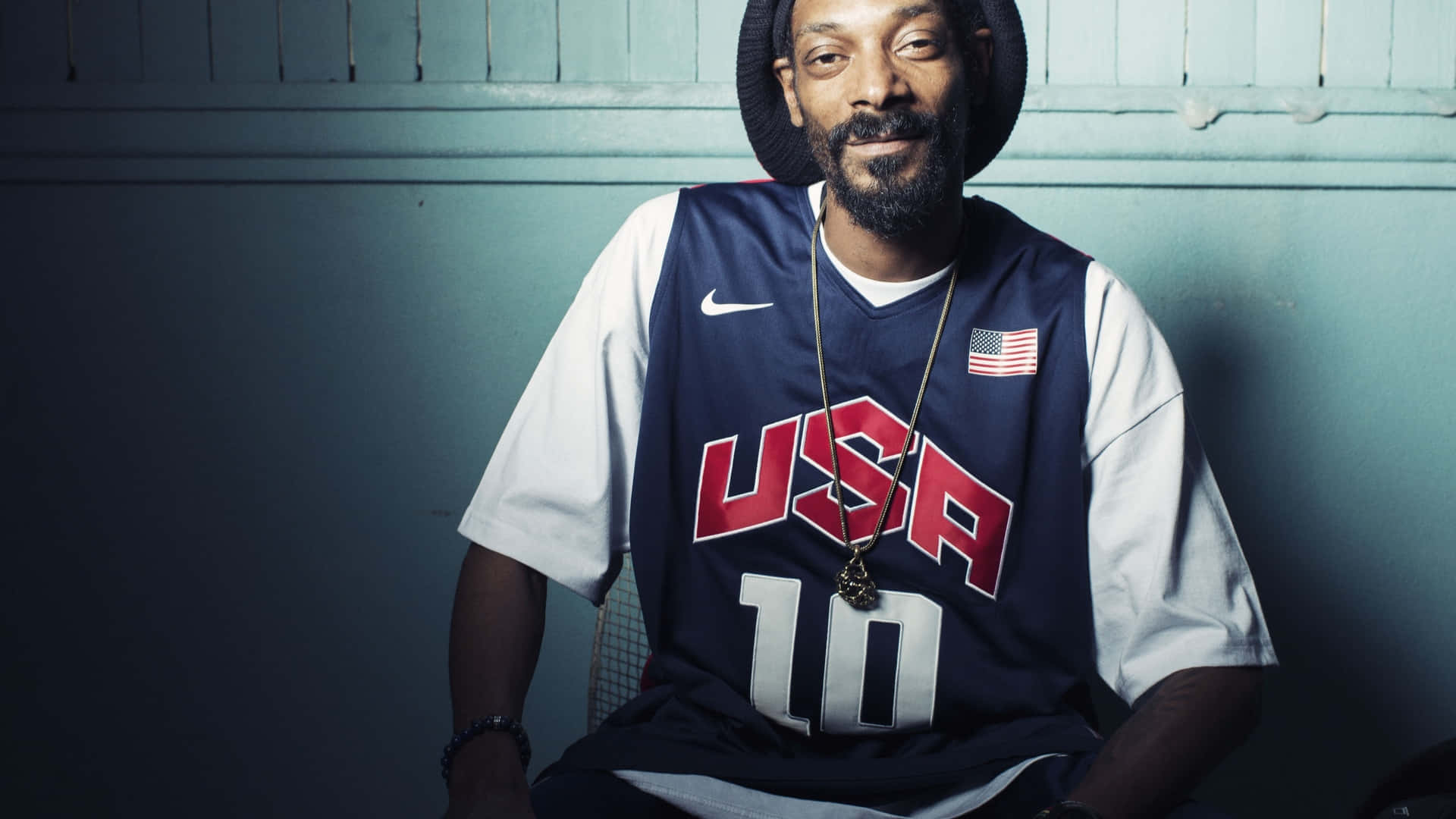 Snoop Dogg 在工作室肖像中穿著美國籃球球衣和帽子。