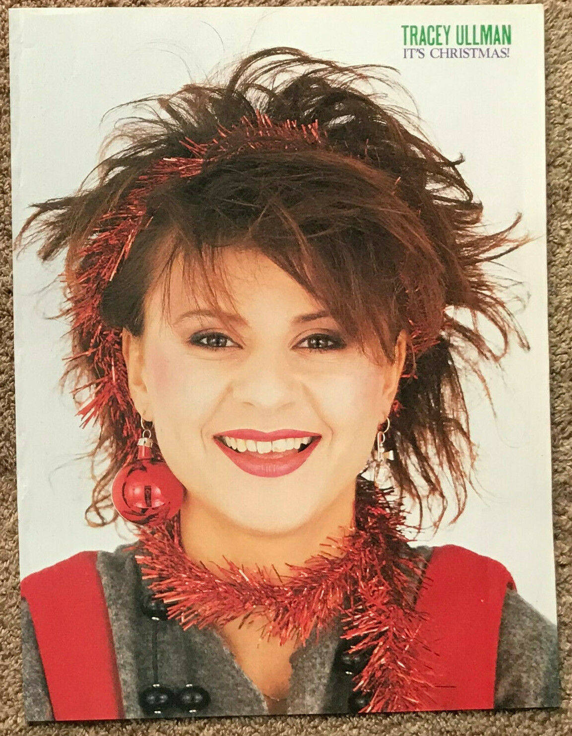 Tracey Ullman 穿著紅色閃粉節日服裝對著鏡頭微笑。