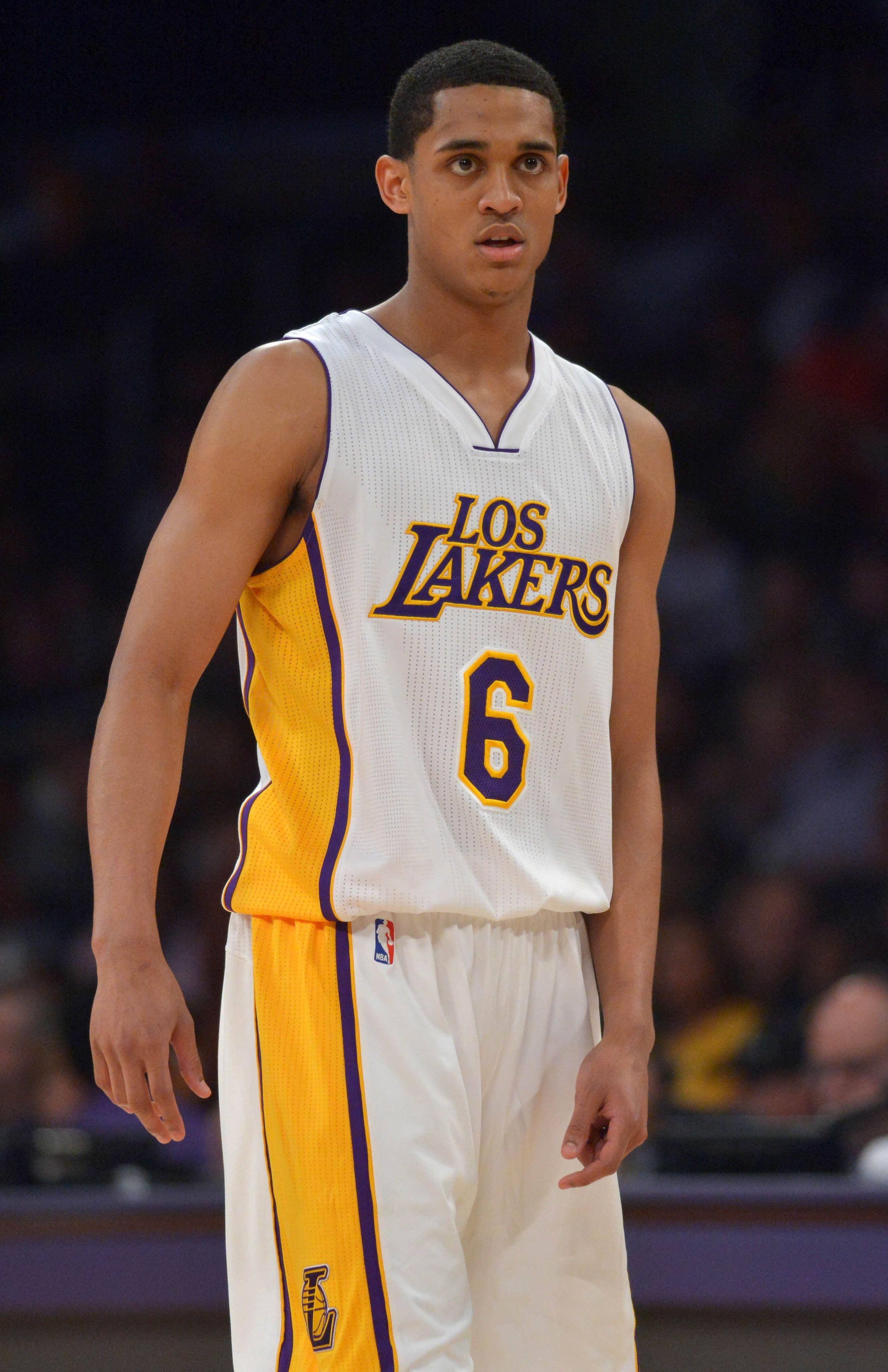 年輕球員Jordan Clarkson 壁紙 — 一位專注的籃球運動員，身穿白色、黃色和紫色的洛杉磯湖人隊6號球衣，在比賽中站在球場上。