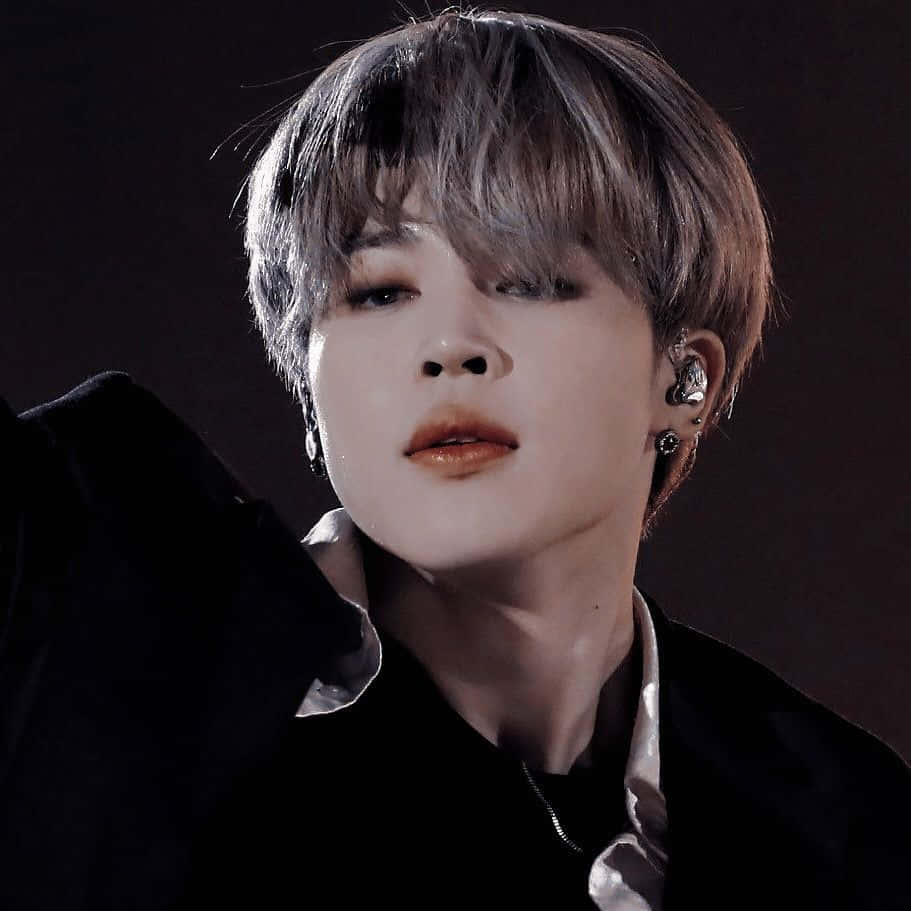 Jimin Aesthetic 桌布 壁紙 — 年輕男子嘅特寫肖像，佢有短層次頭髮同多個耳環，背景係深色。