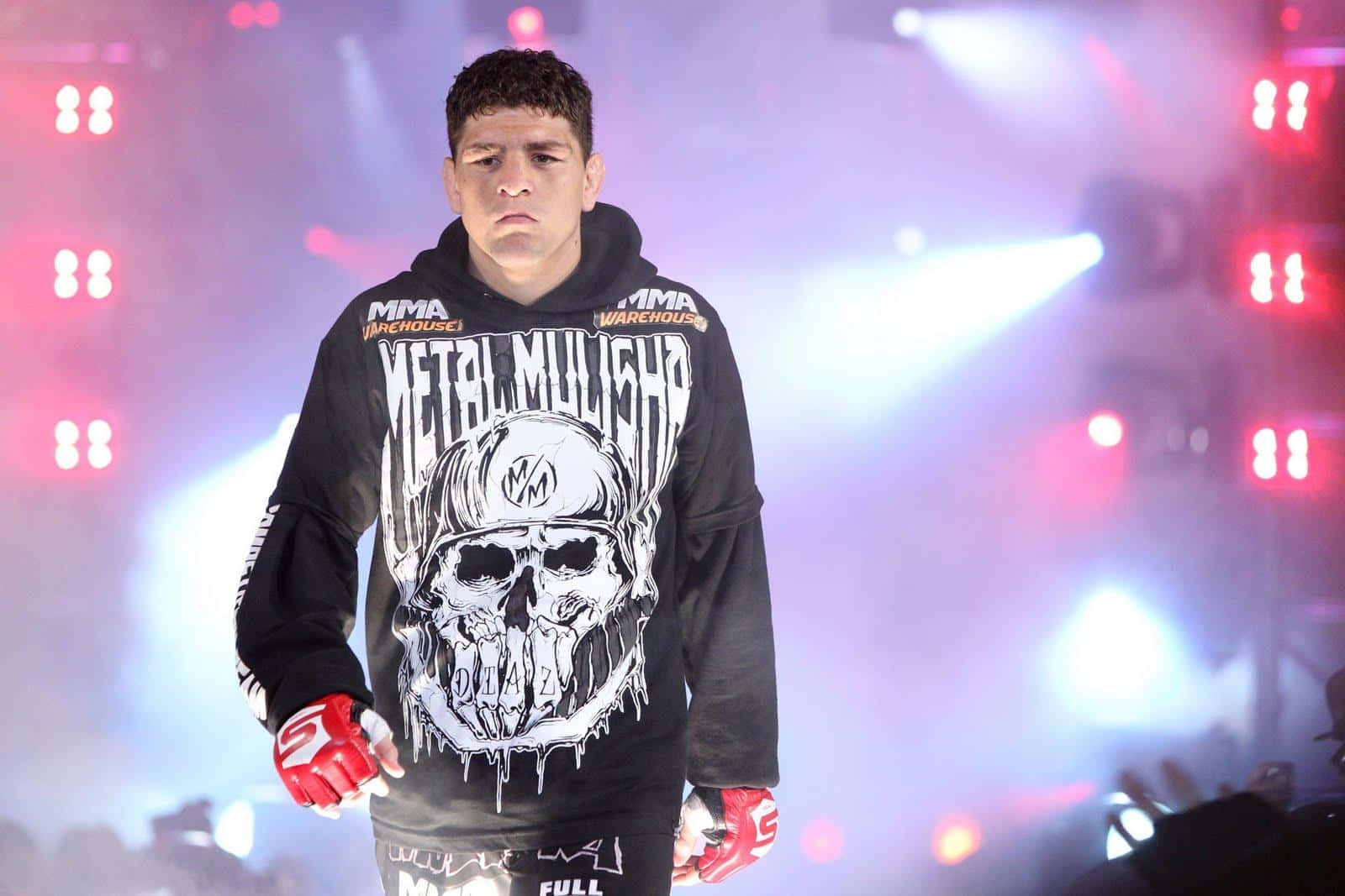 MMA拳手穿著骷髏連帽衫，戴著紅色手套走過場館燈光。