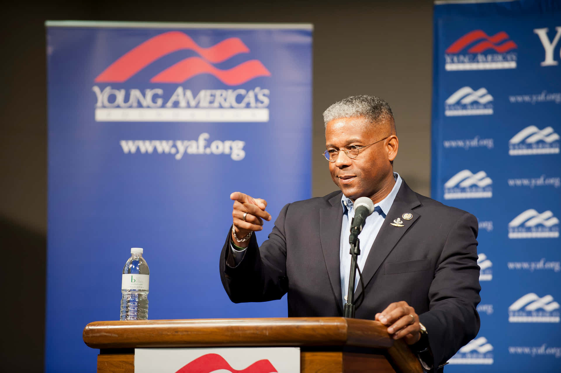 身穿西裝的男子在講台上發言，身後有Young America's Foundation橫幅。