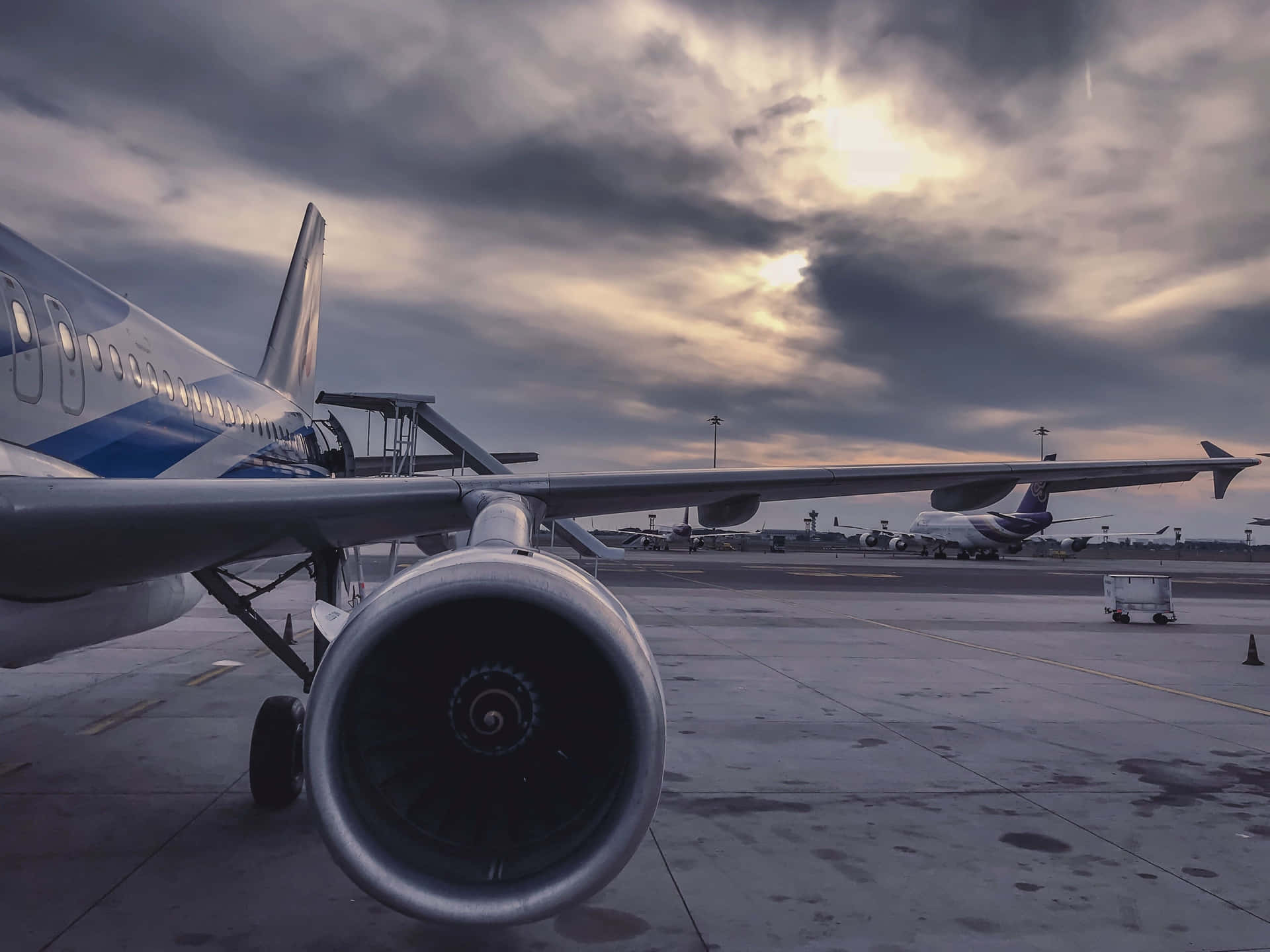 黃昏多雲天空下停機坪上飛機引擎的特寫