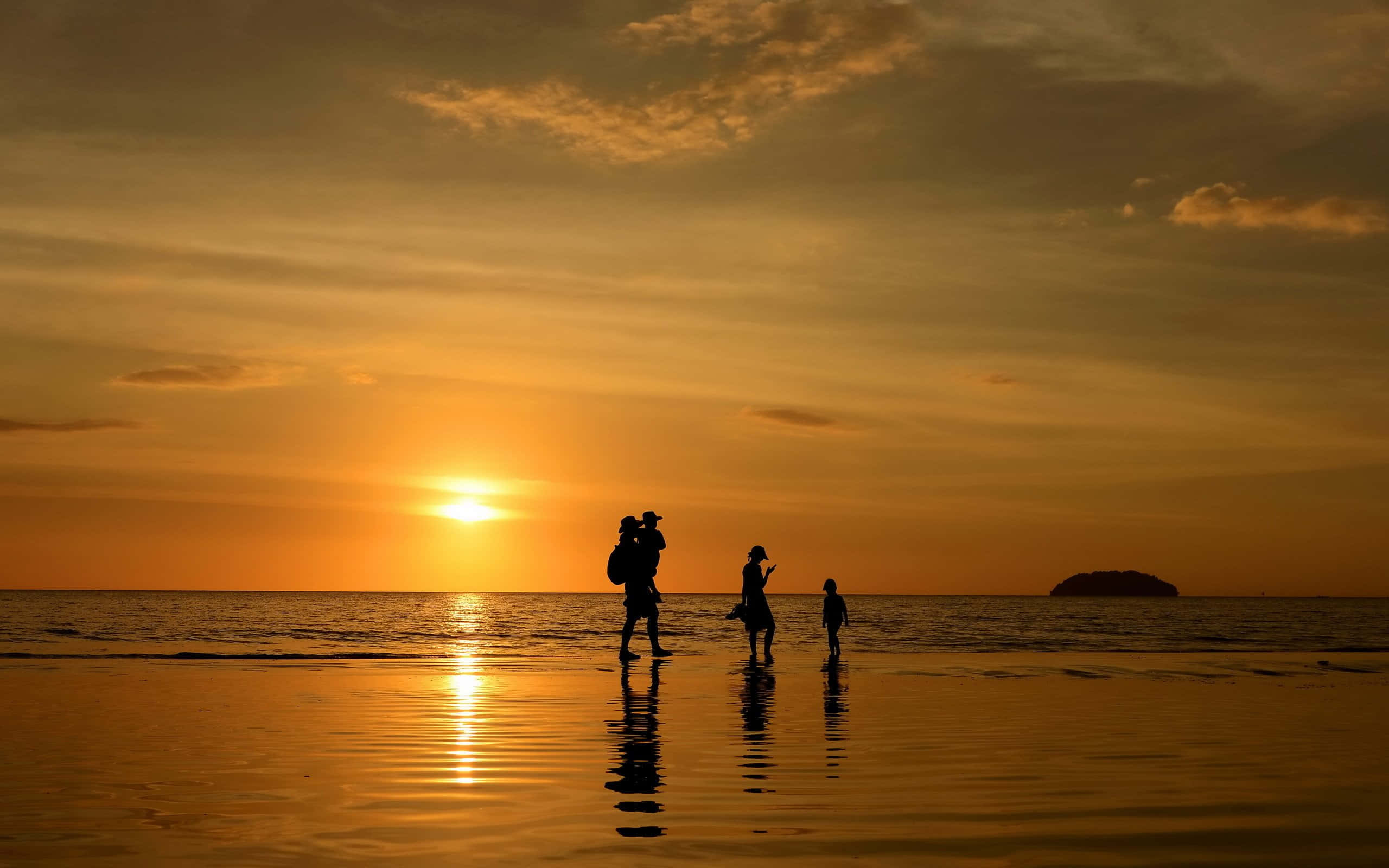 幸福家庭日落海灘 壁紙 — 剪影家庭沿著濕漉漉的海灘行走，夕陽如火橙色，在水面上投下長長的倒影。