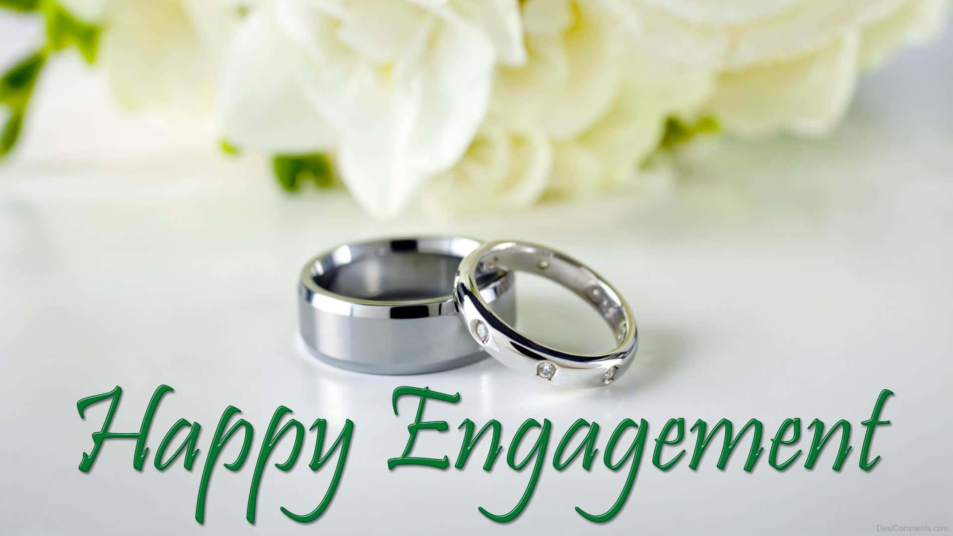 兩枚銀色訂婚戒指，配白玫瑰和綠色 Happy Engagement 文字。