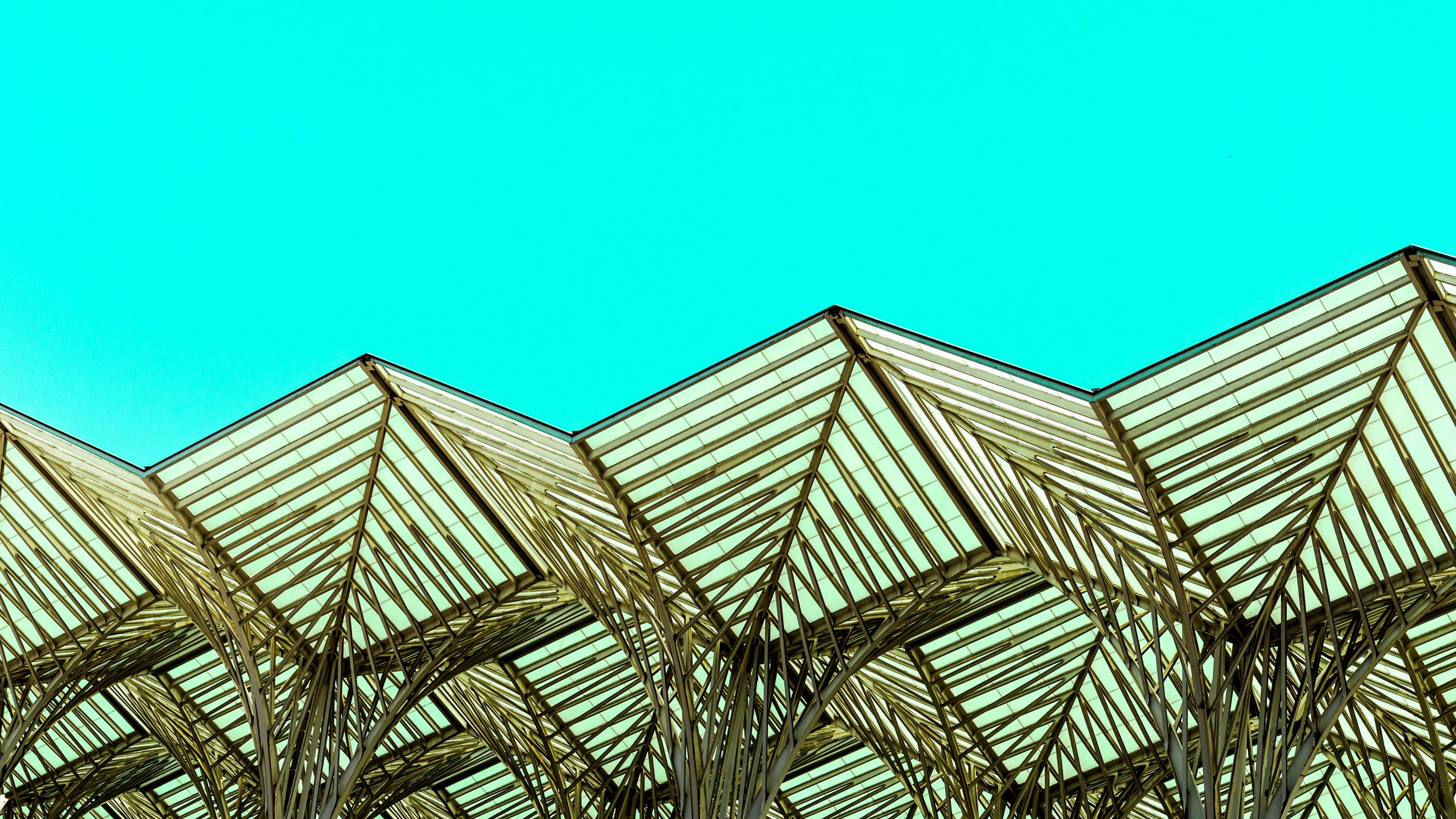 Building 桌布 壁紙 — 幾何玻璃和金屬屋頂結構，襯托著充滿活力的綠松色天空。