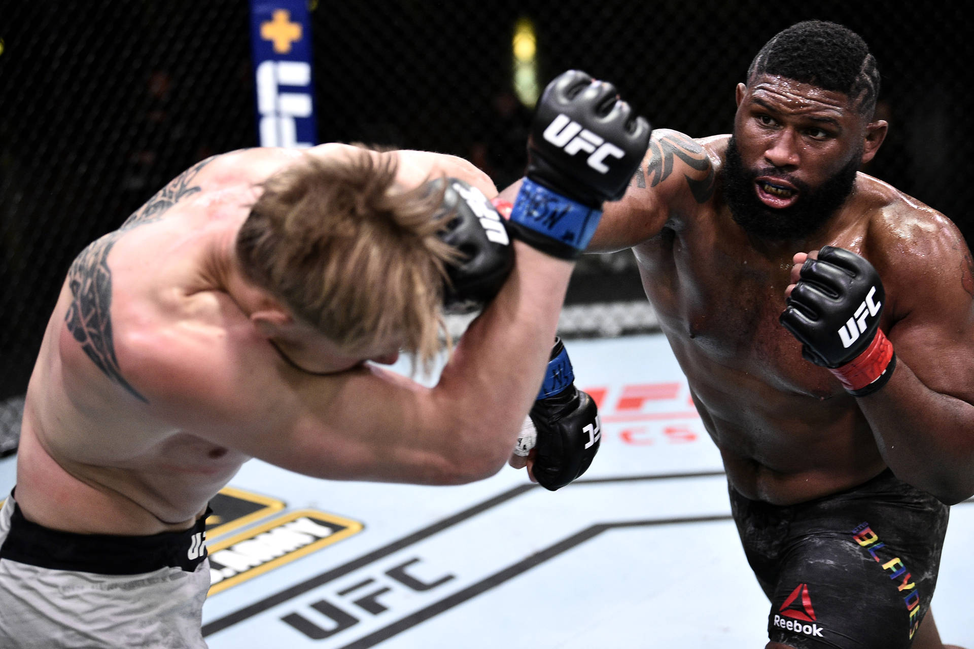 兩名男性拳手在UFC鐵籠內於比賽中交換強力一拳。