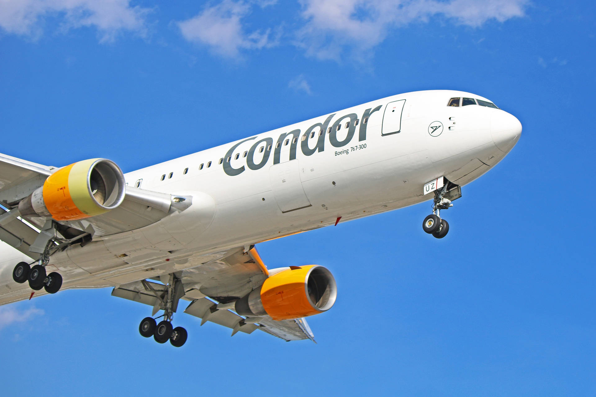Condor波音777-300飛機放下起落架，在藍天中攀升。