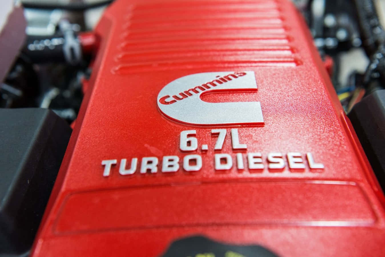 康明斯6.7L渦輪柴油引擎 壁紙 — 鮮紅色Cummins 6.7L Turbo Diesel引擎蓋特寫，帶有粗體白色字體和金屬標誌。