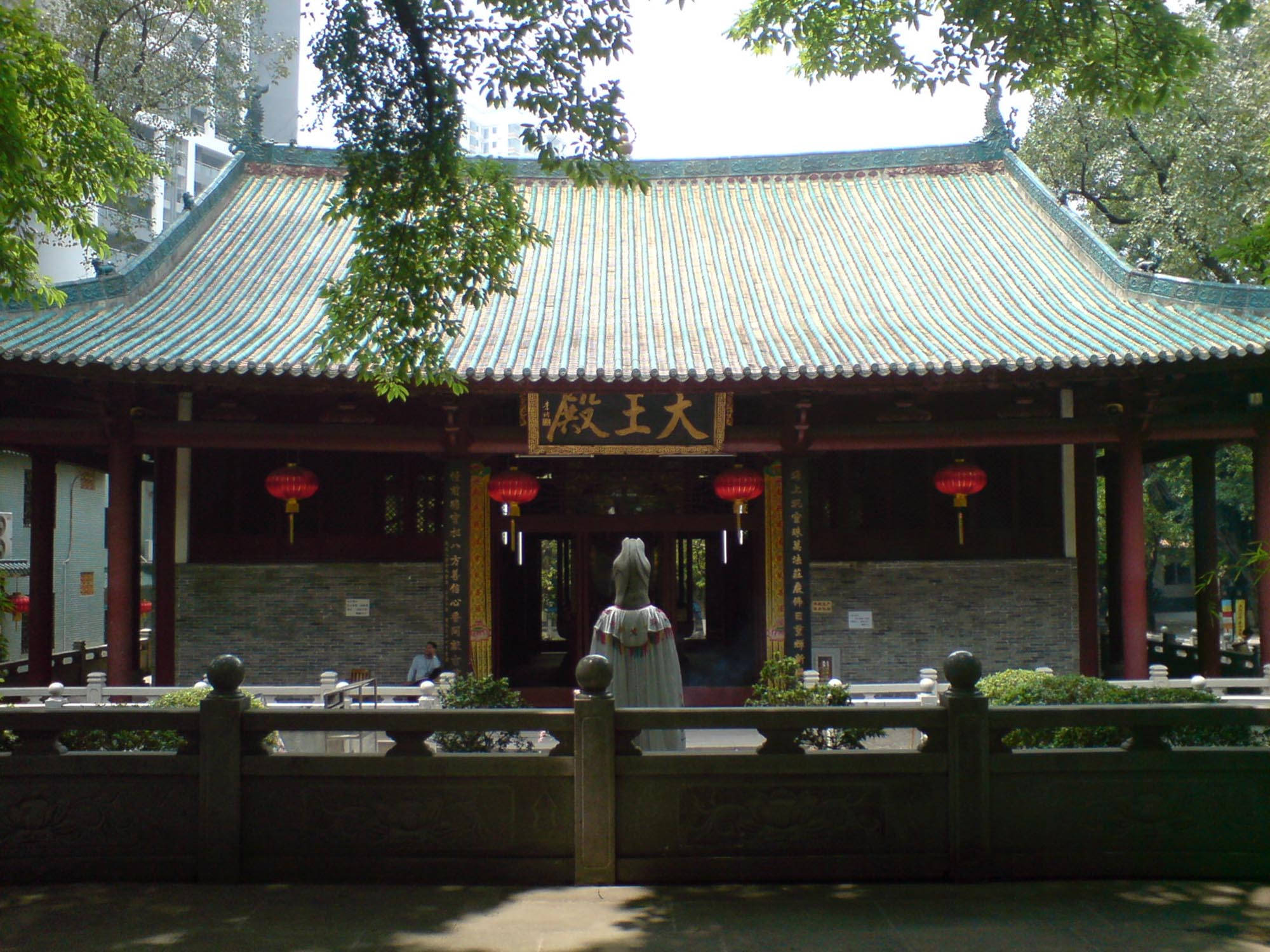 廣州六榕寺 壁紙 — 傳統中式寺廟，綠色瓦頂、紅色柱子和懸掛的燈籠，在晴朗的日子被茂密的樹木環繞。
