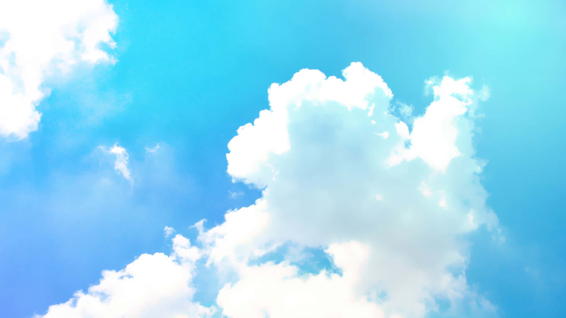 Blue Skies 桌布 壁紙 — 廣闊嘅天藍色天空充滿咗 fluffy 白色雲朵，沐浴喺明亮陽光下。