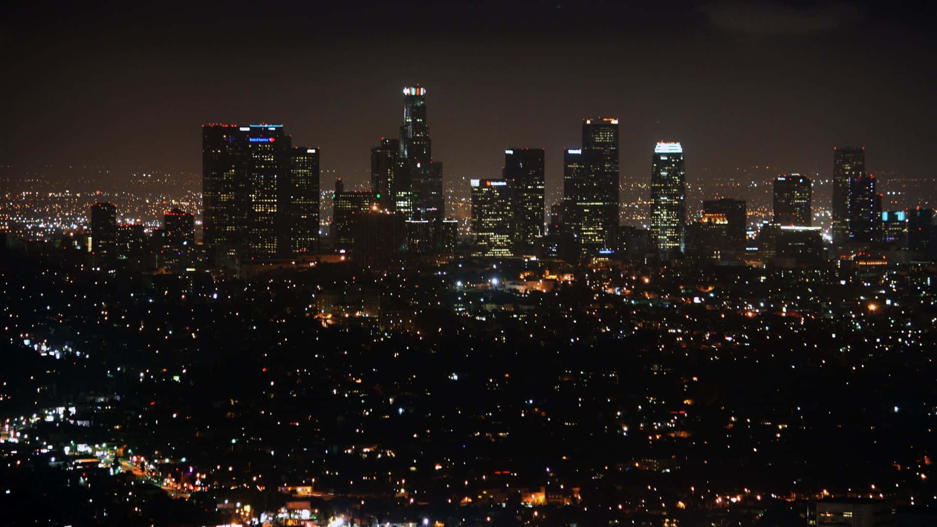 洛杉磯 桌布 壁紙 — 廣闊城市景觀的 panoramic 夜景，高聳的摩天大樓在黑暗的天空中閃耀。