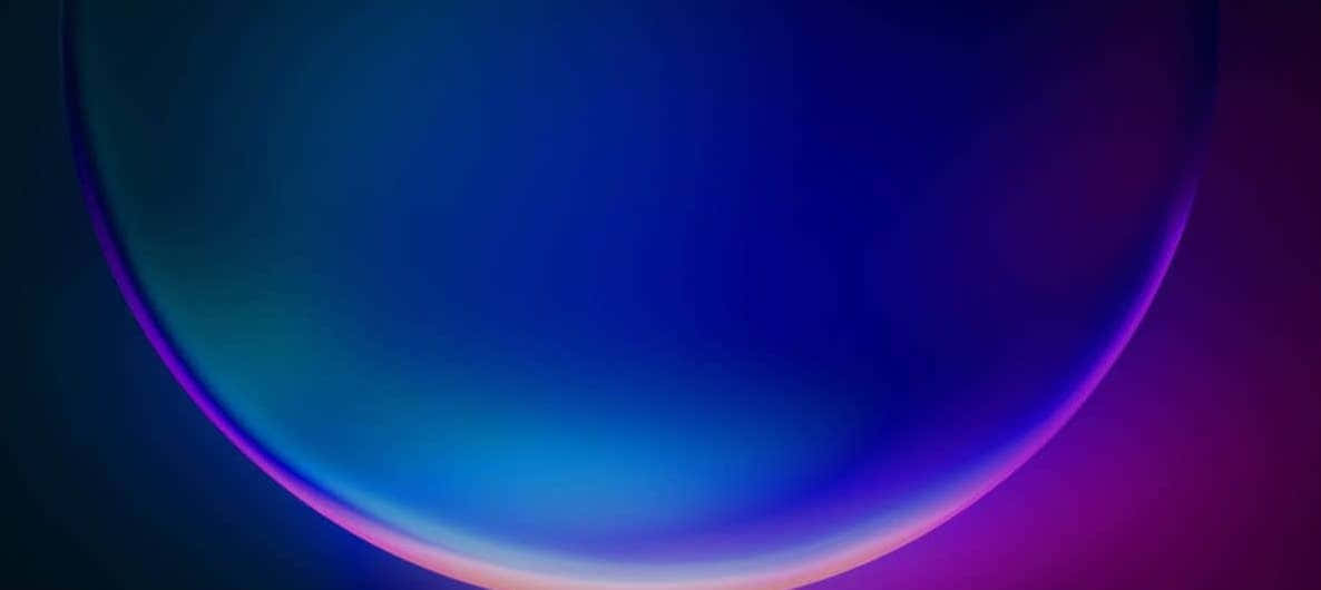 廣闊壯麗的藍色螢幕背景 壁紙 — 一個發光的漸變球體在深色背景上從深藍色過渡到充滿活力的紫色和粉紅色。