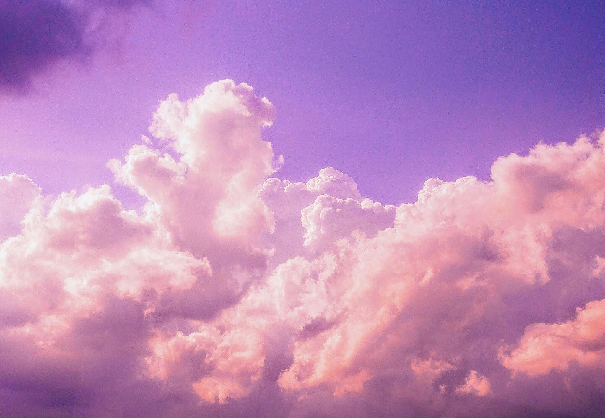 Cloud Aesthetic 桌布 壁紙 — 廣闊如棉的雲朵在暮色天空中散發著柔和的粉紅色和紫色光芒。