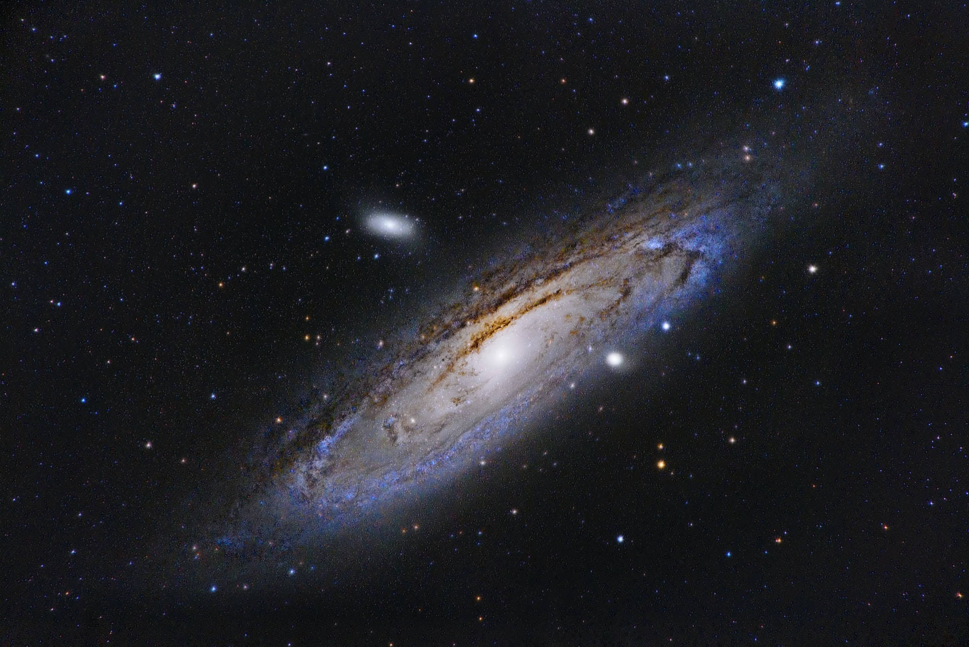在深空中被星星包圍的藍色和金色旋臂螺旋星系。