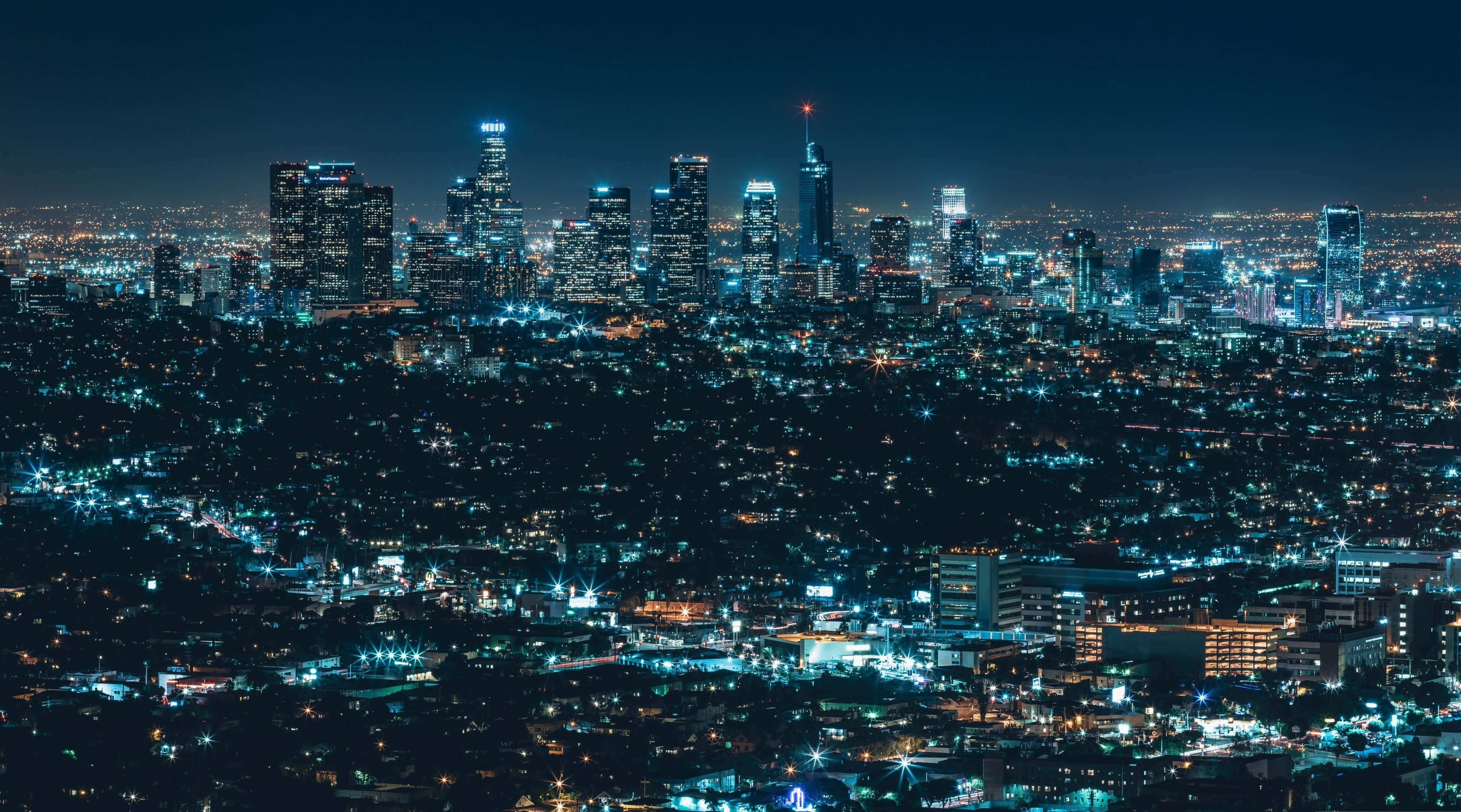 4K Display 桌布 壁紙 — 廣闊的夜景，高聳的摩天大樓在黑暗的天空中閃耀。