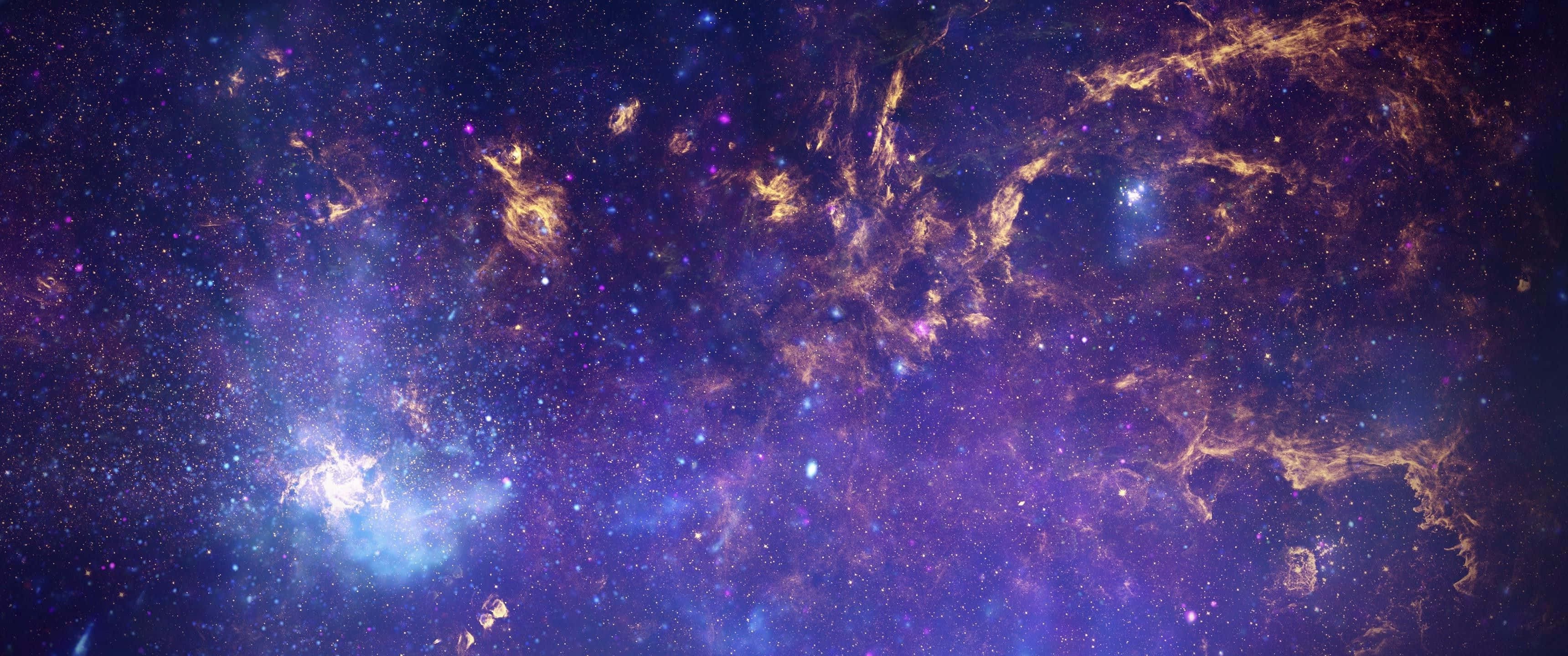 Galaxy Stars 桌布 壁紙 — 廣闊的宇宙星雲在星空背景下以深紫色和金色色調旋轉。