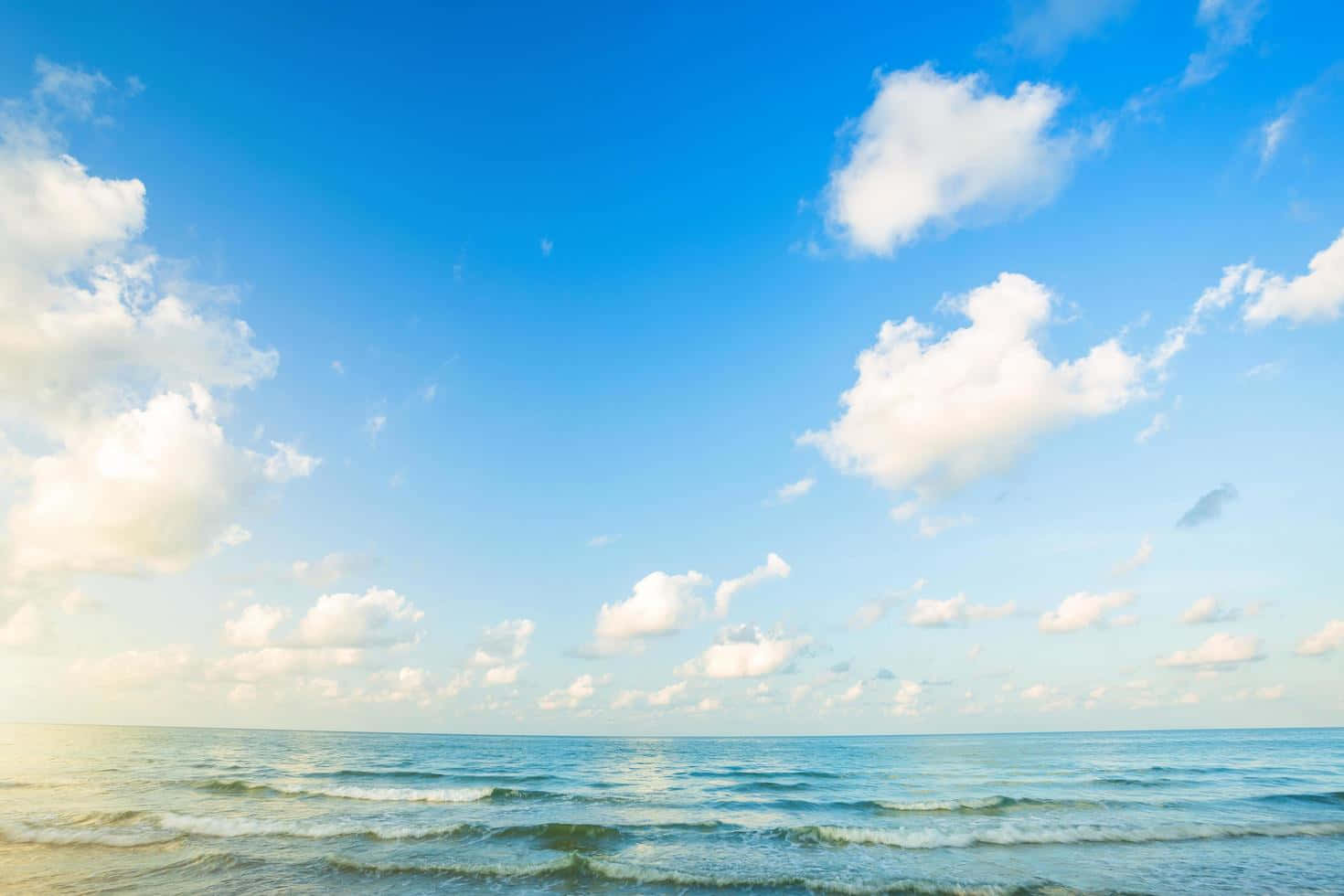 Horizon 桌布 壁紙 — 廣闊的海洋波浪在晴朗的日子裡，在點綴著蓬鬆白雲的明亮藍天下翻滾。
