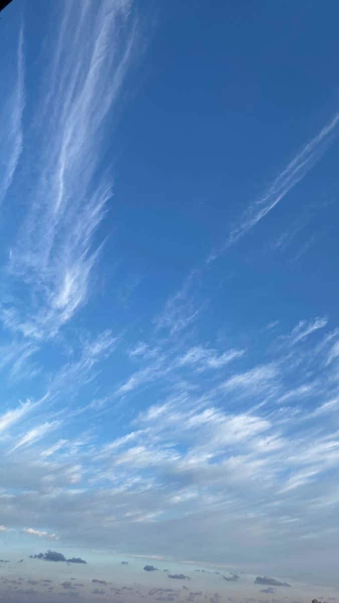 Blue Horizon 桌布 壁紙 — 廣闊蔚藍的天空中，纖細的白色卷雲在遙遠的地平線上空飄移。